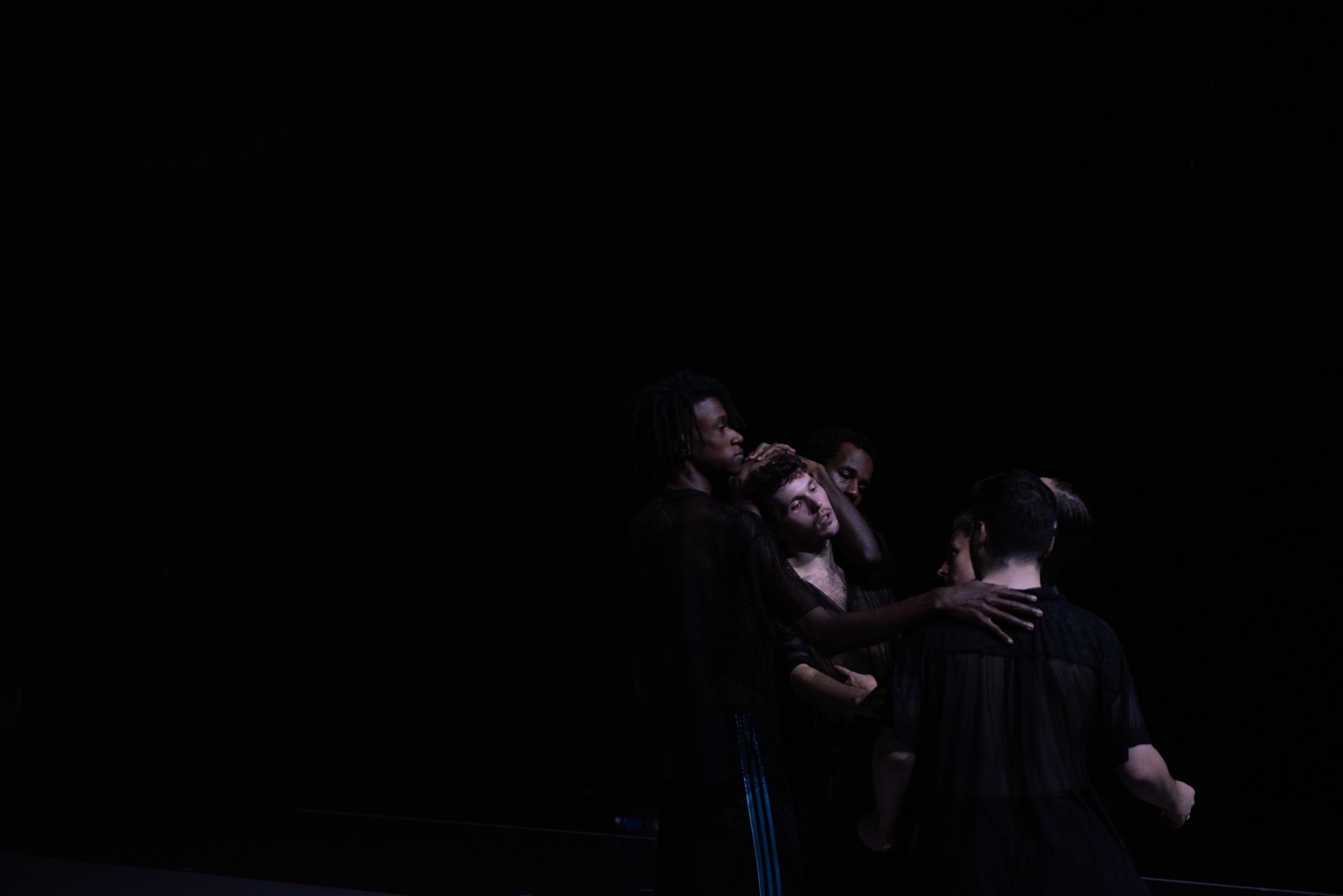 Danseurs en groupe sur un scène sombre