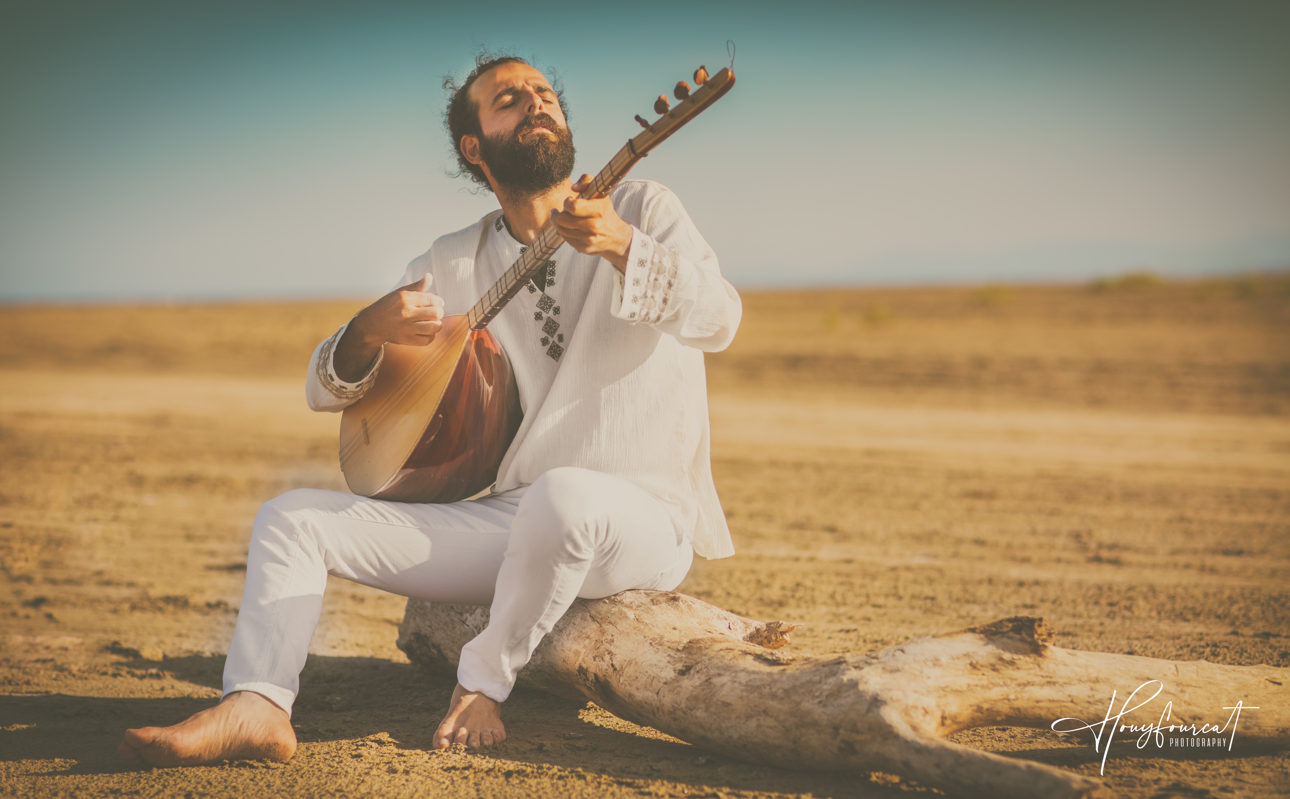Musician dressed up in white and playing an instrument