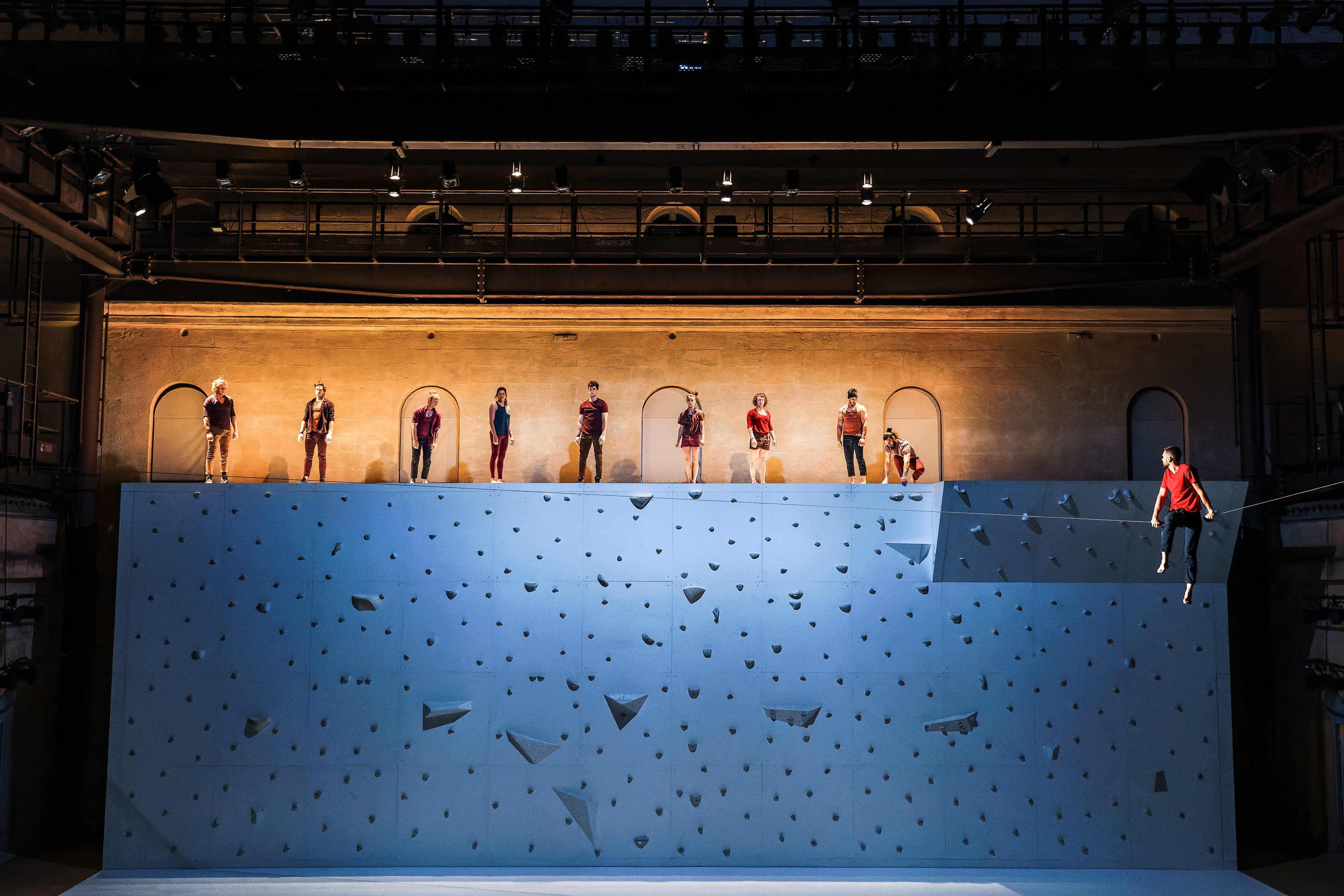 Danseurs dessus d’un mur d’escalade derrière d’un scène