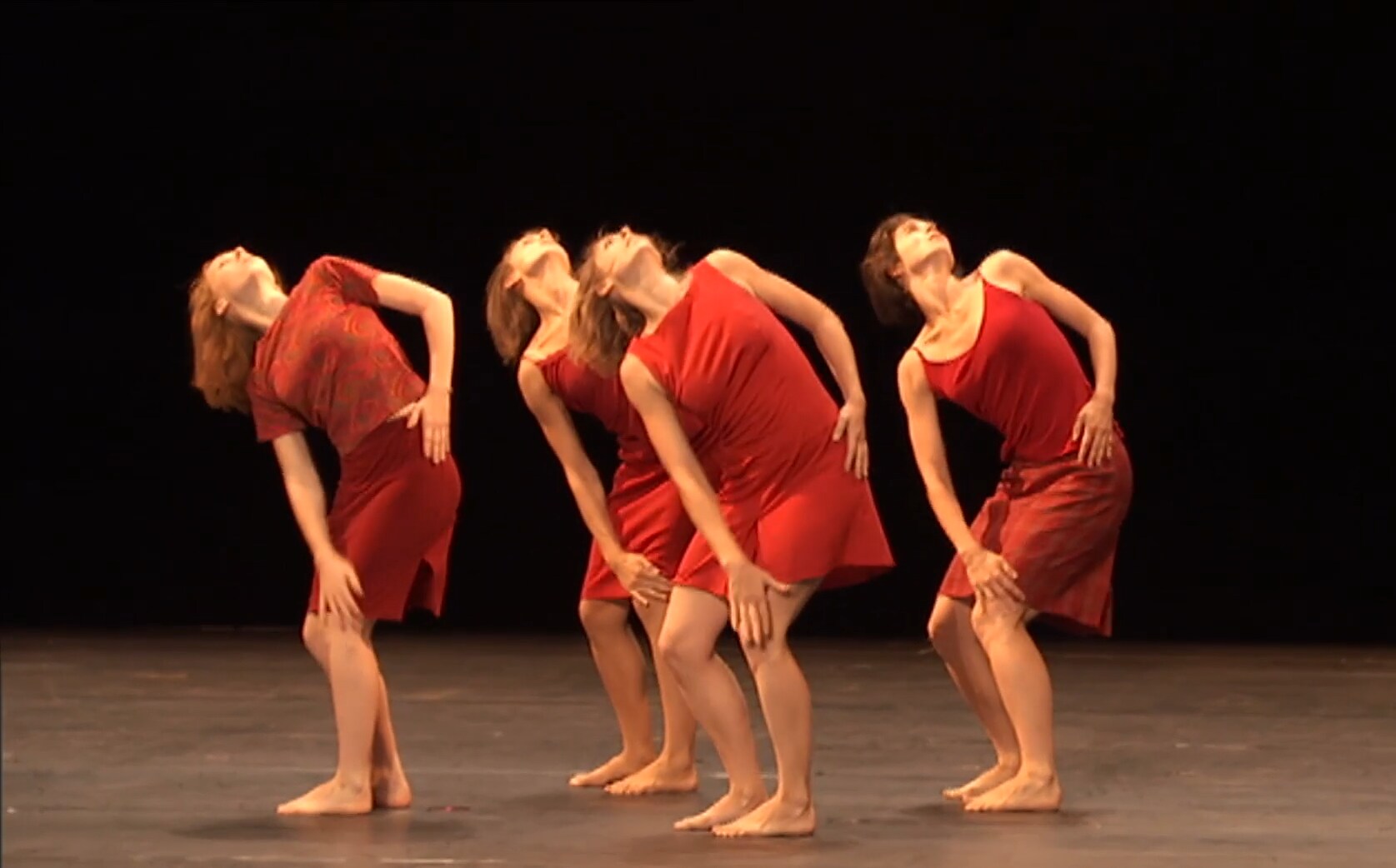 quatre danseurs en robes rouges levant les yeux 