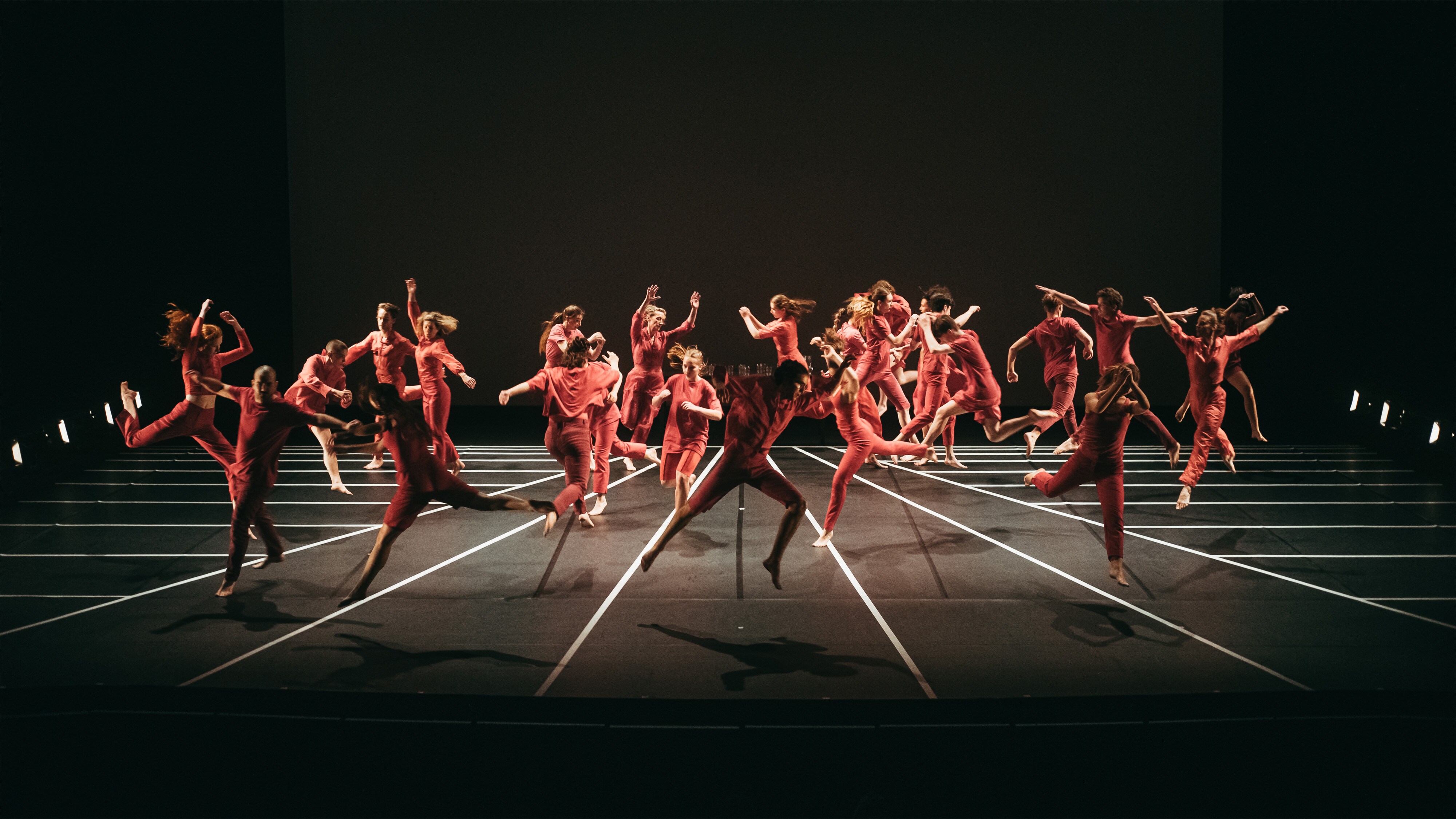 Jumping dancers, in the piece Red Notes, choreographed by Andy de Groat