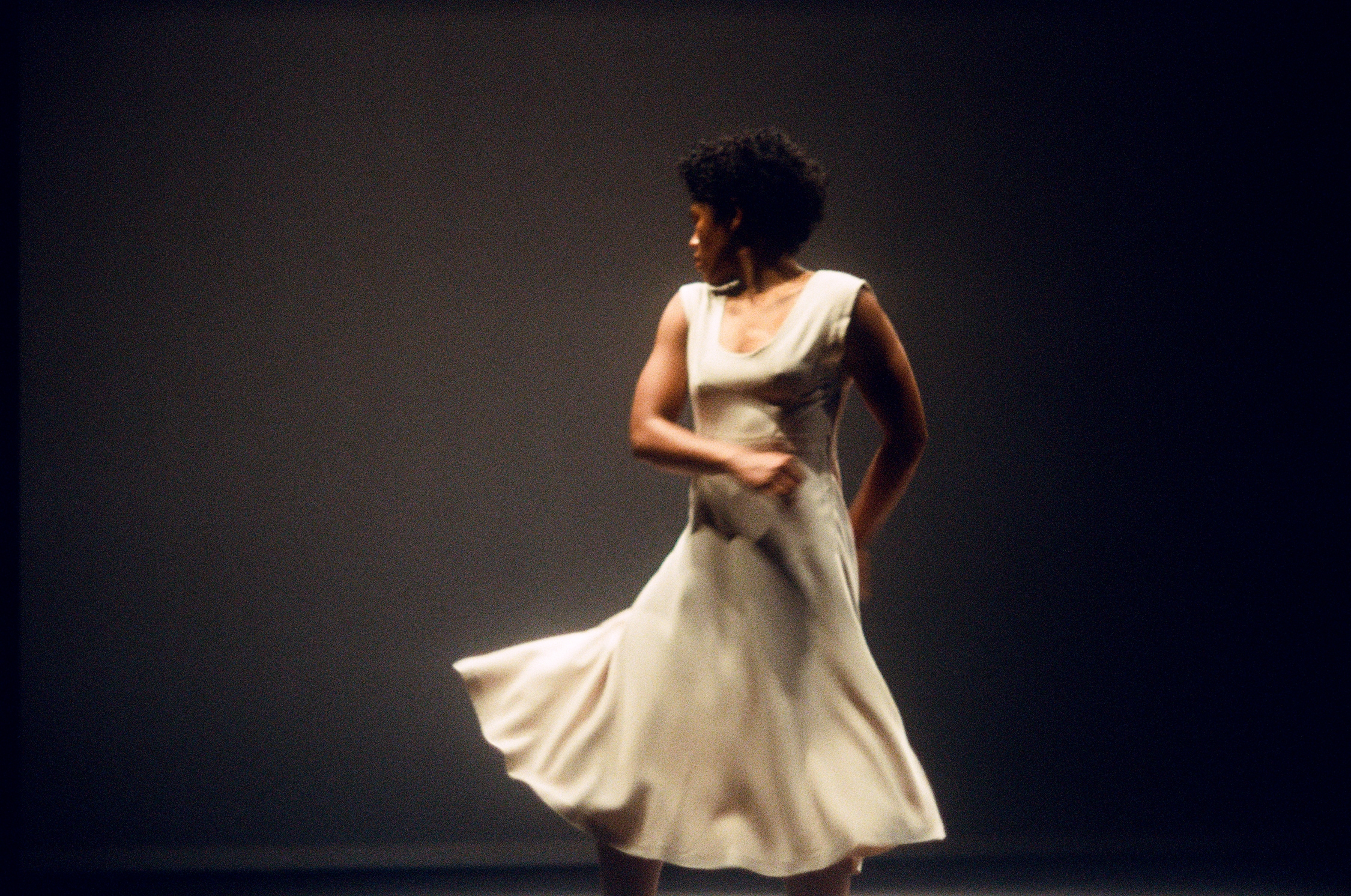 Danseuse en robe blanche regardant vers l’arrière