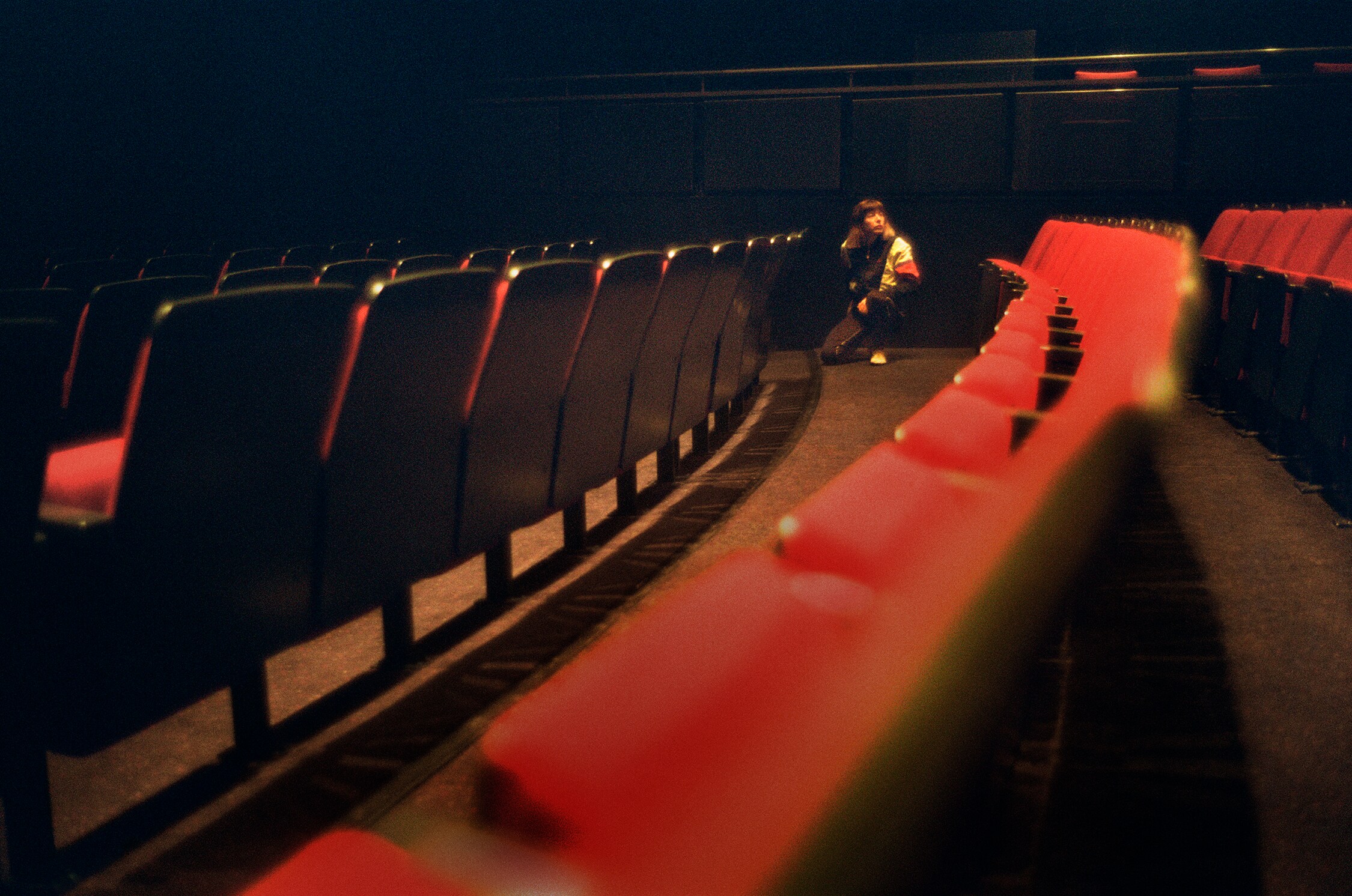 Rows of theater seats with artist in the back