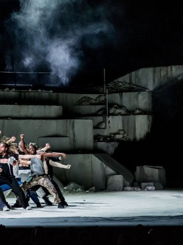 group of dancers on the left and a man on the right mixing.