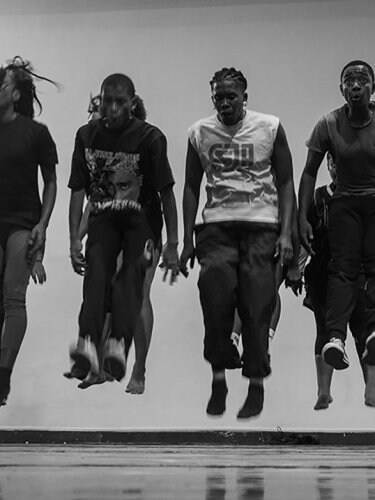 quatre danseurs entrain de sauter les jambes tendus en avant