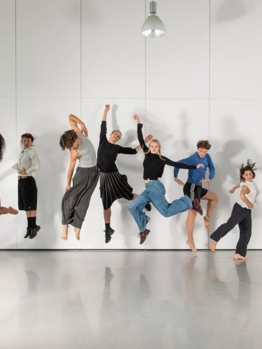 Ten dancers jumping on a white background.