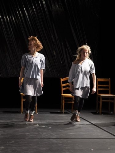 4 dancers standing in front of chairs 