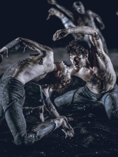 dancers performing in the mud