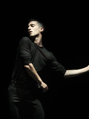 a dancer in black performing a solo 