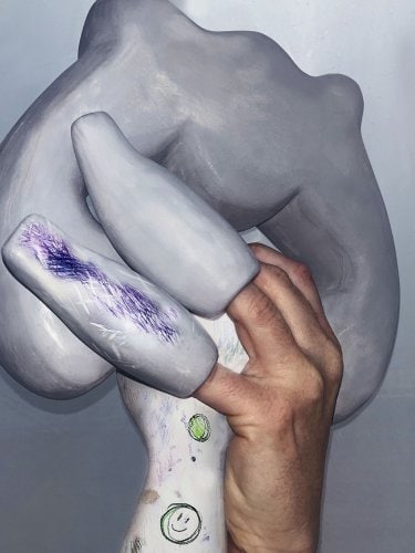 Hand holding a grey abstract sculpture