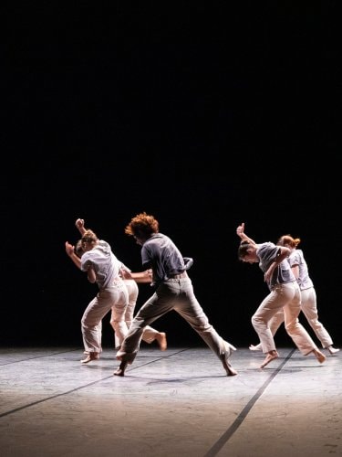 danseurs courant vêtus de blanc sur fond noir