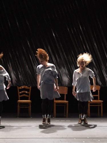 4 dancers standing in front of chairs 