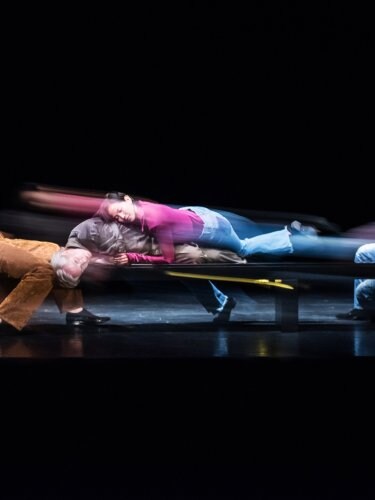 Danseurs assis les uns sur les autres dans des tenues colorées