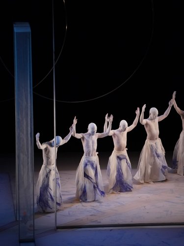 Danseurs alignés portant leurs bras vers le haut. 