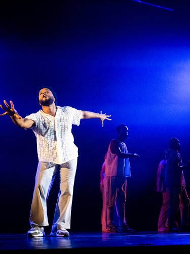 Danseur en costume blanc dans des lumières bleues