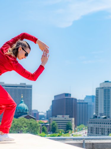 Danseuse sur un toit en costume rouge.  