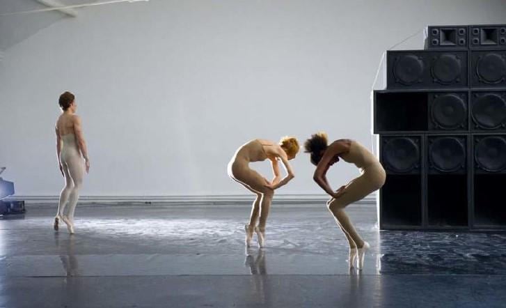 Three dancers on pointe dressed in flesh-toned costumes 