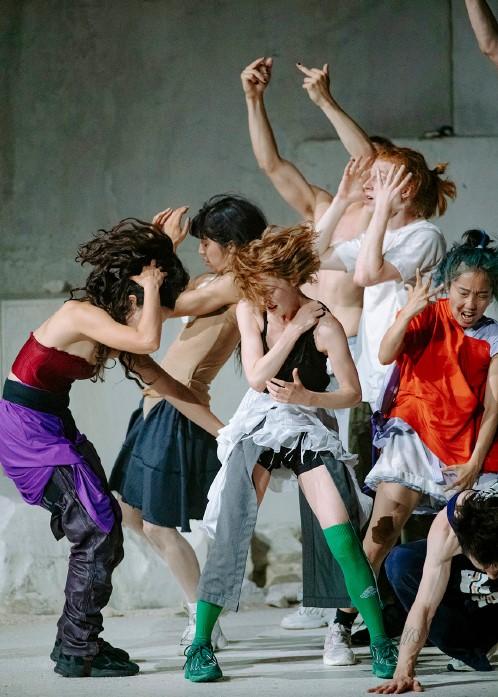 Dancers in colored costumes leaping and moving