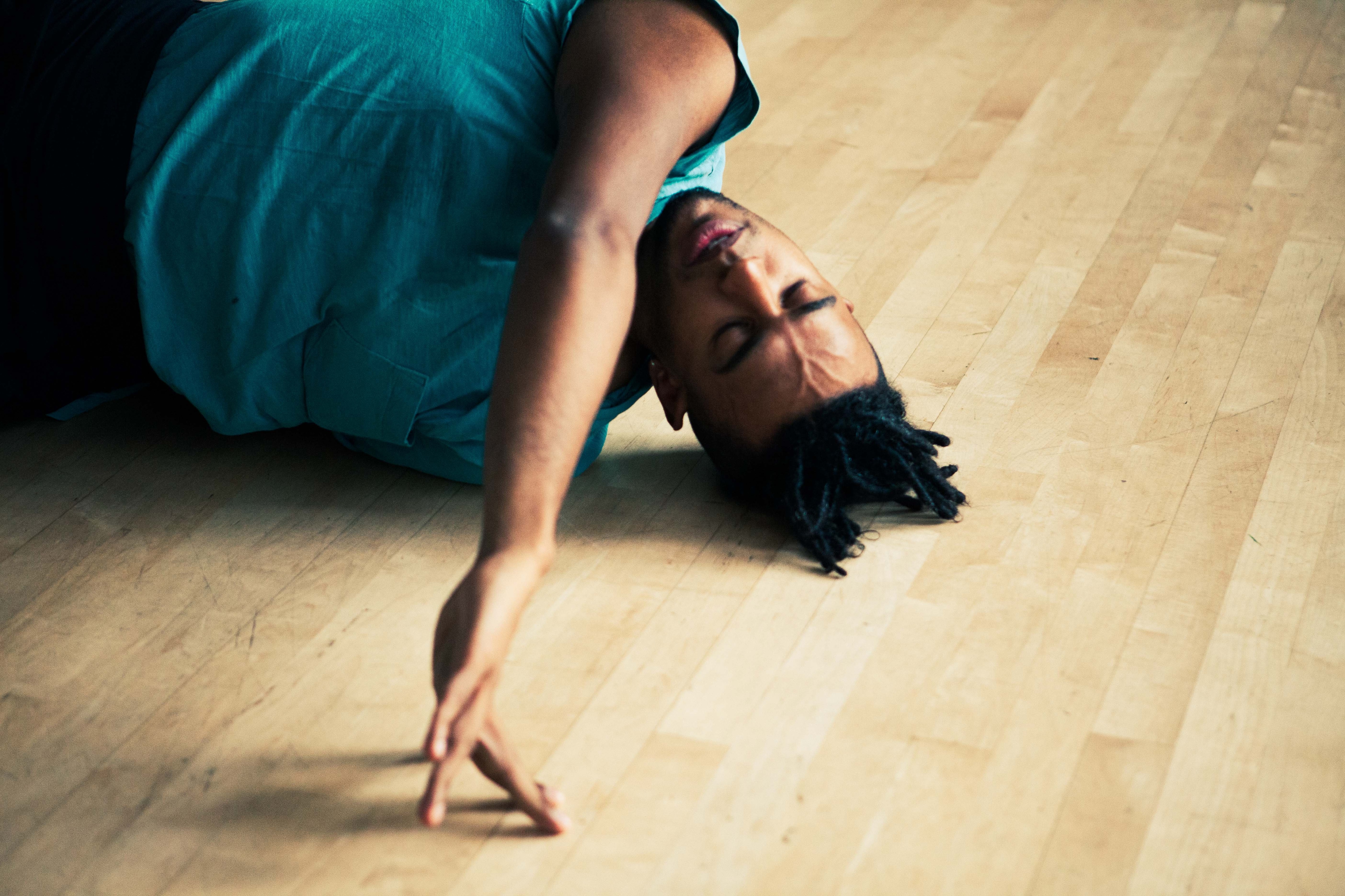 a close-up of Jonathan González on the floor moving on his shoulder