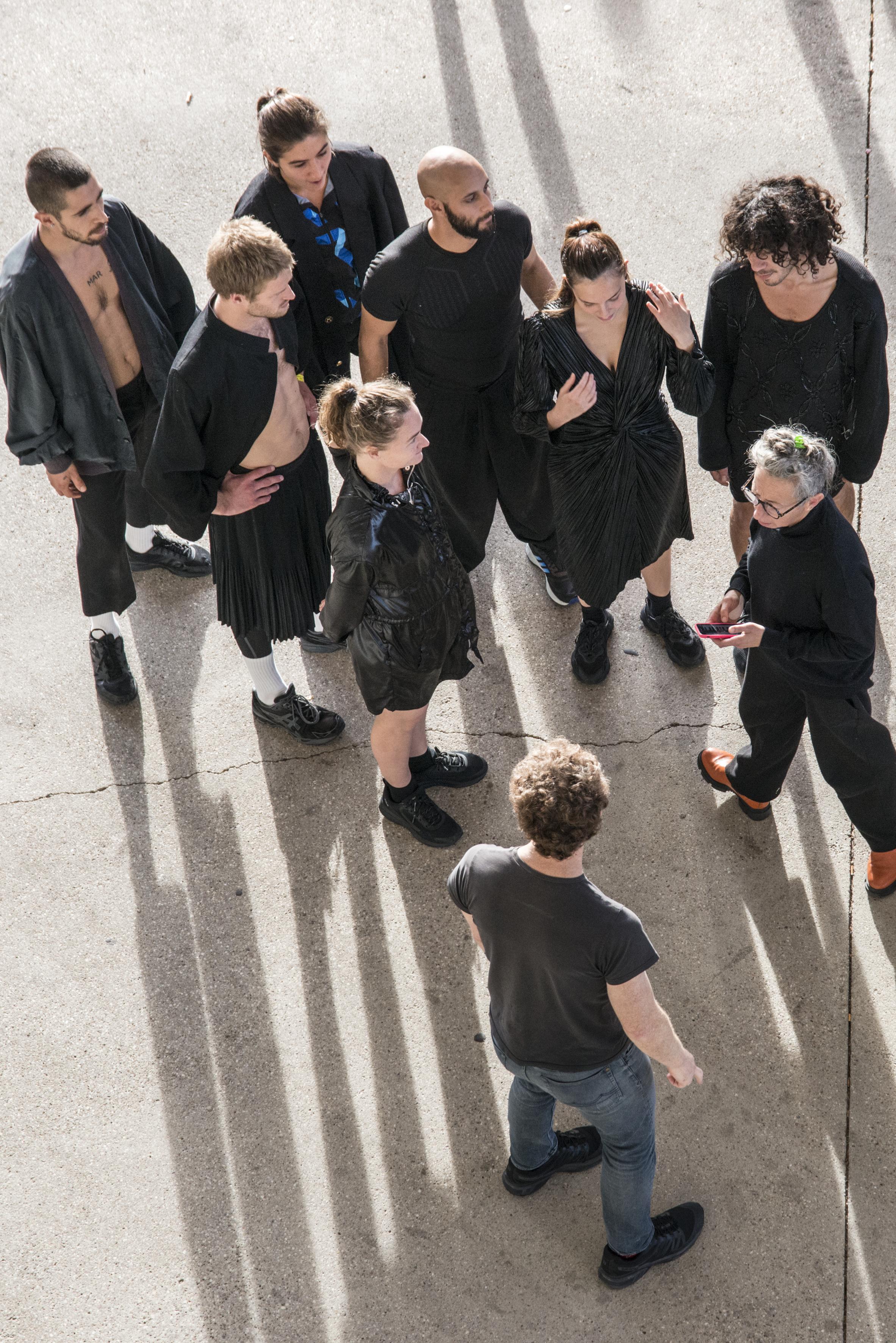 vue en plongée de Boris Charmatz et des danseurs, vêtus de noir sur le parvis du Centre Pompidou-Metz