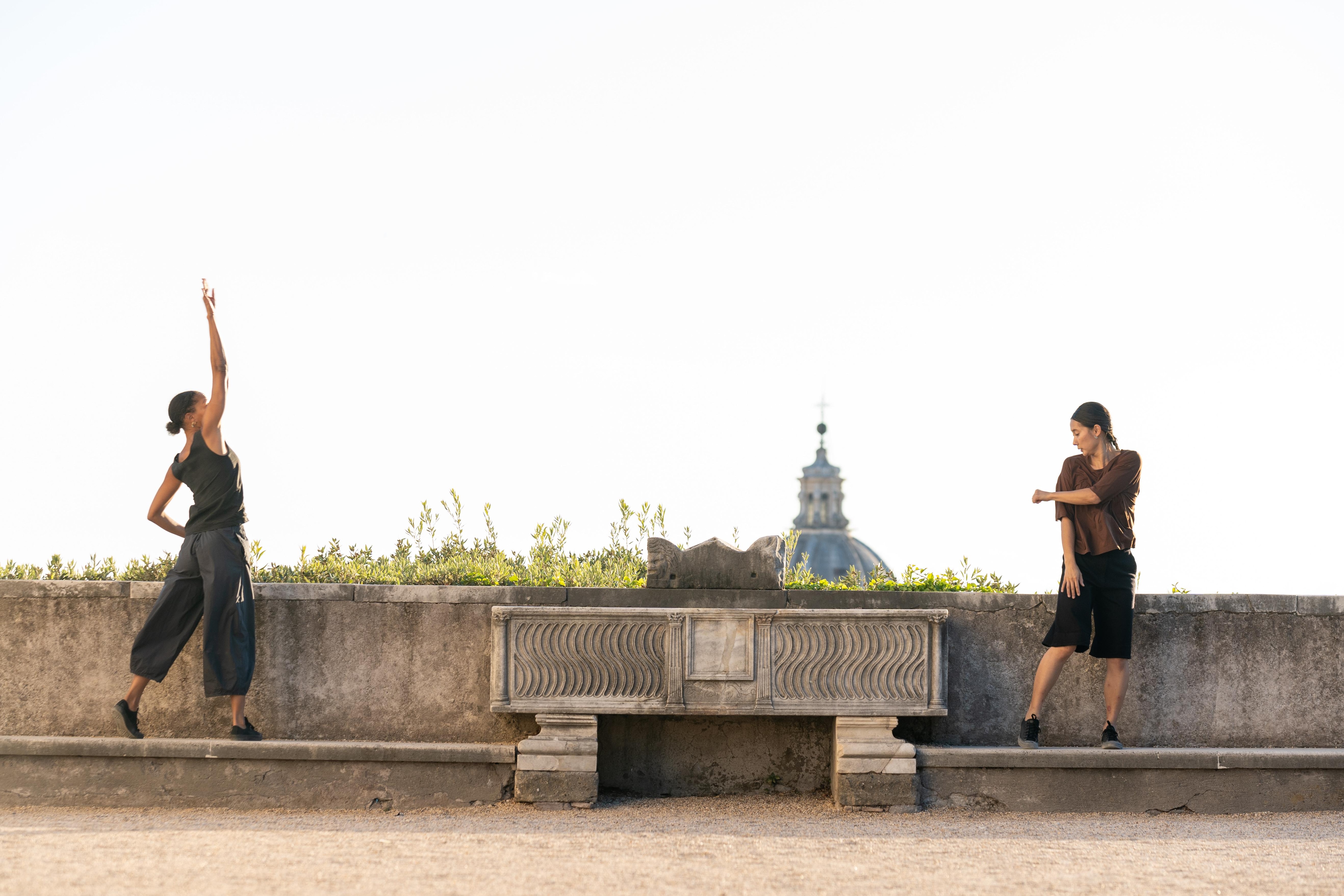 Danseuses face à face debout sur un muret en béton