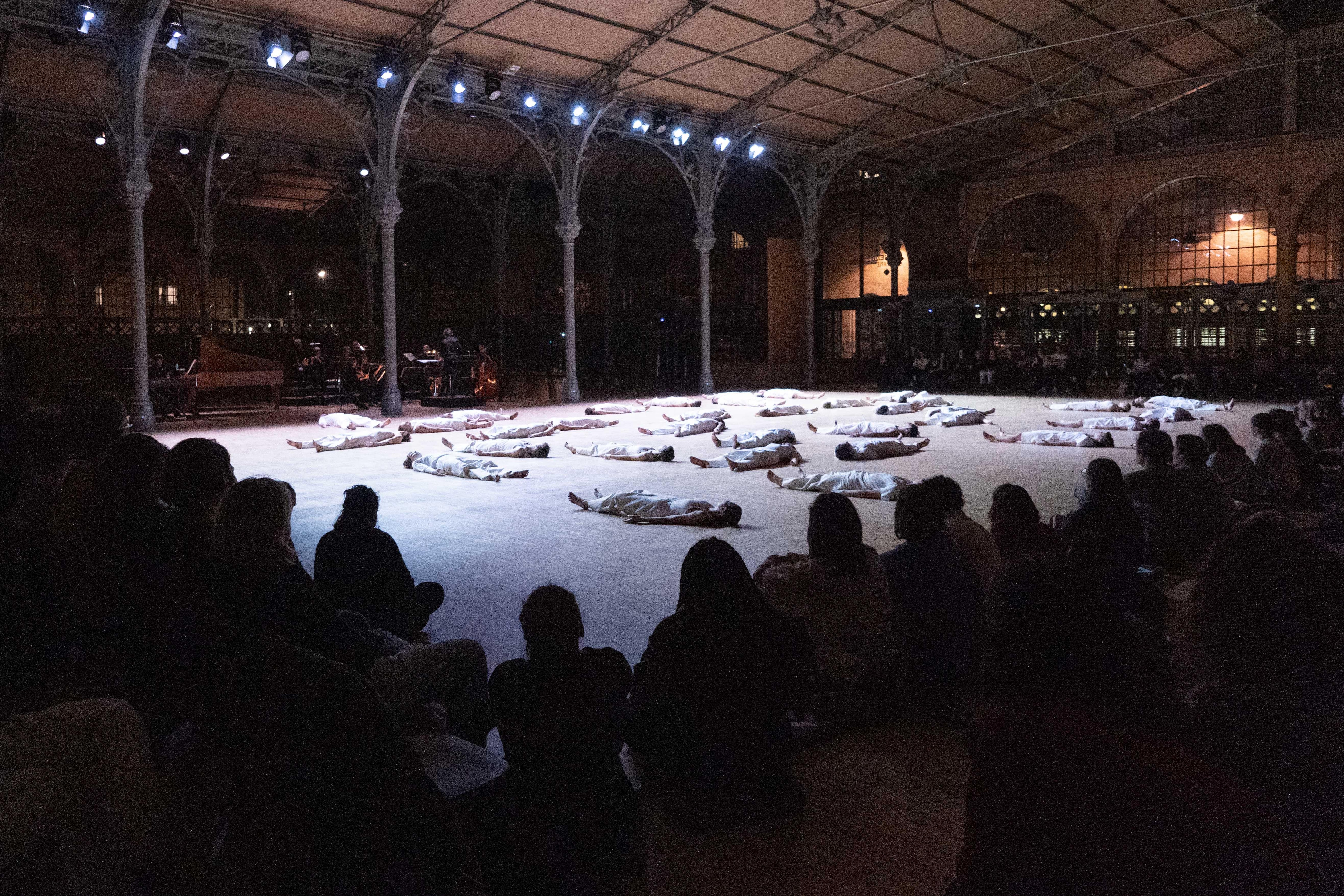 Dancers lying on the floor, audience in the foreground