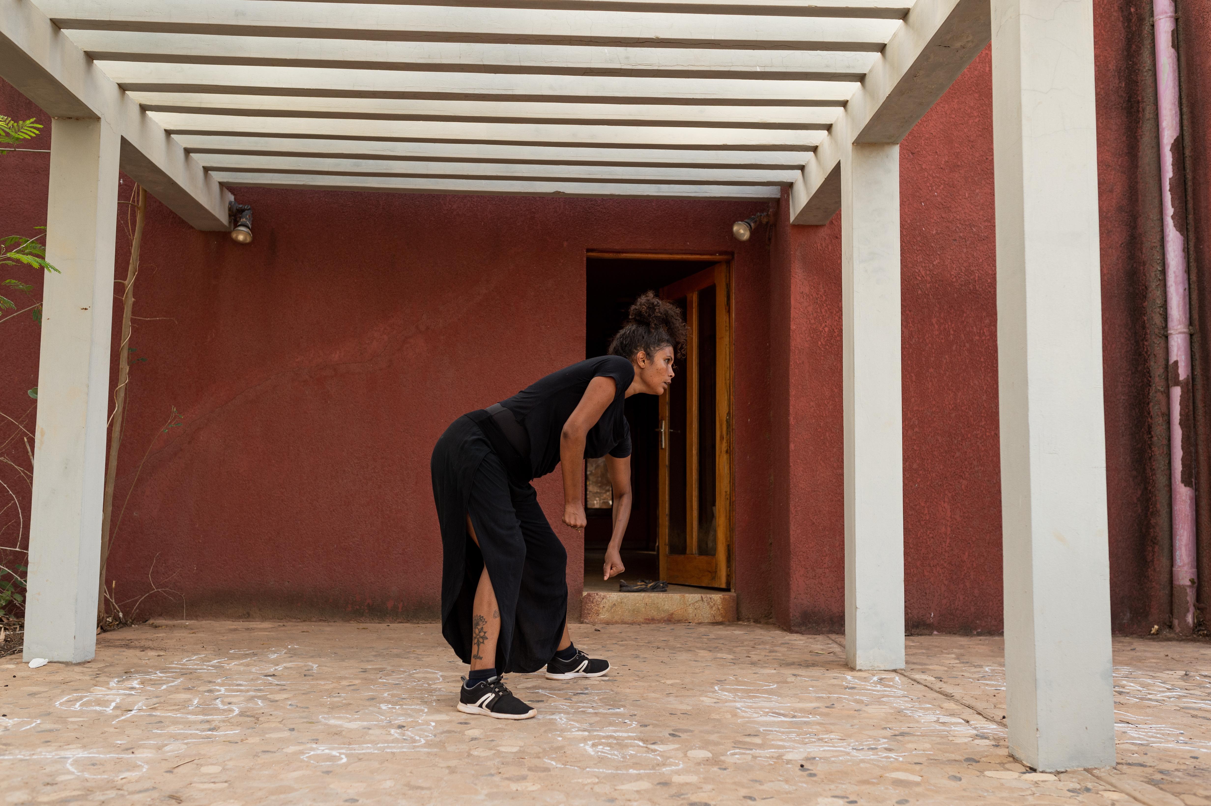 Dancer leaning forward in an oudoor courtyard