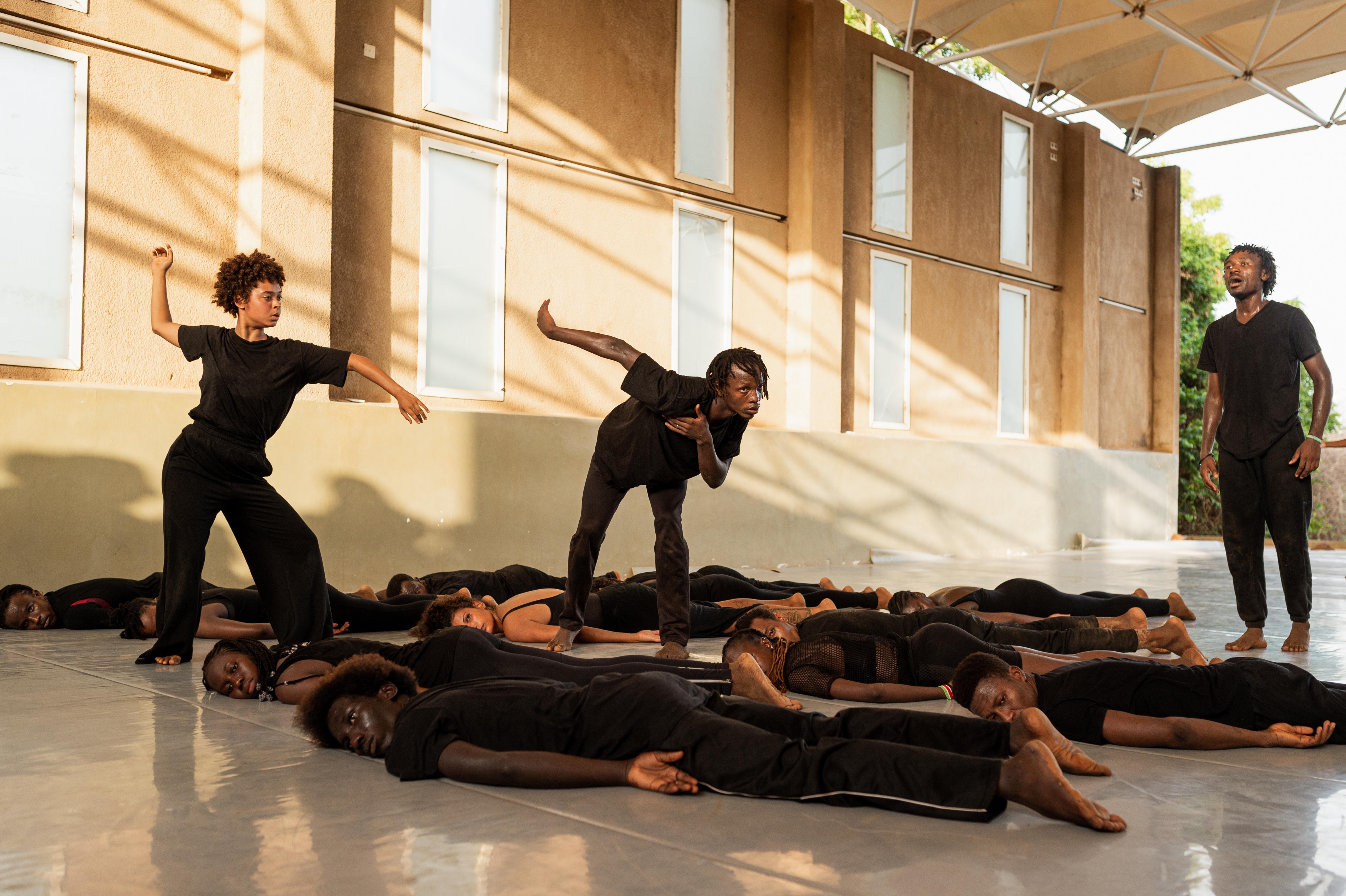 Dancers lying on the floor, two others dancing standing