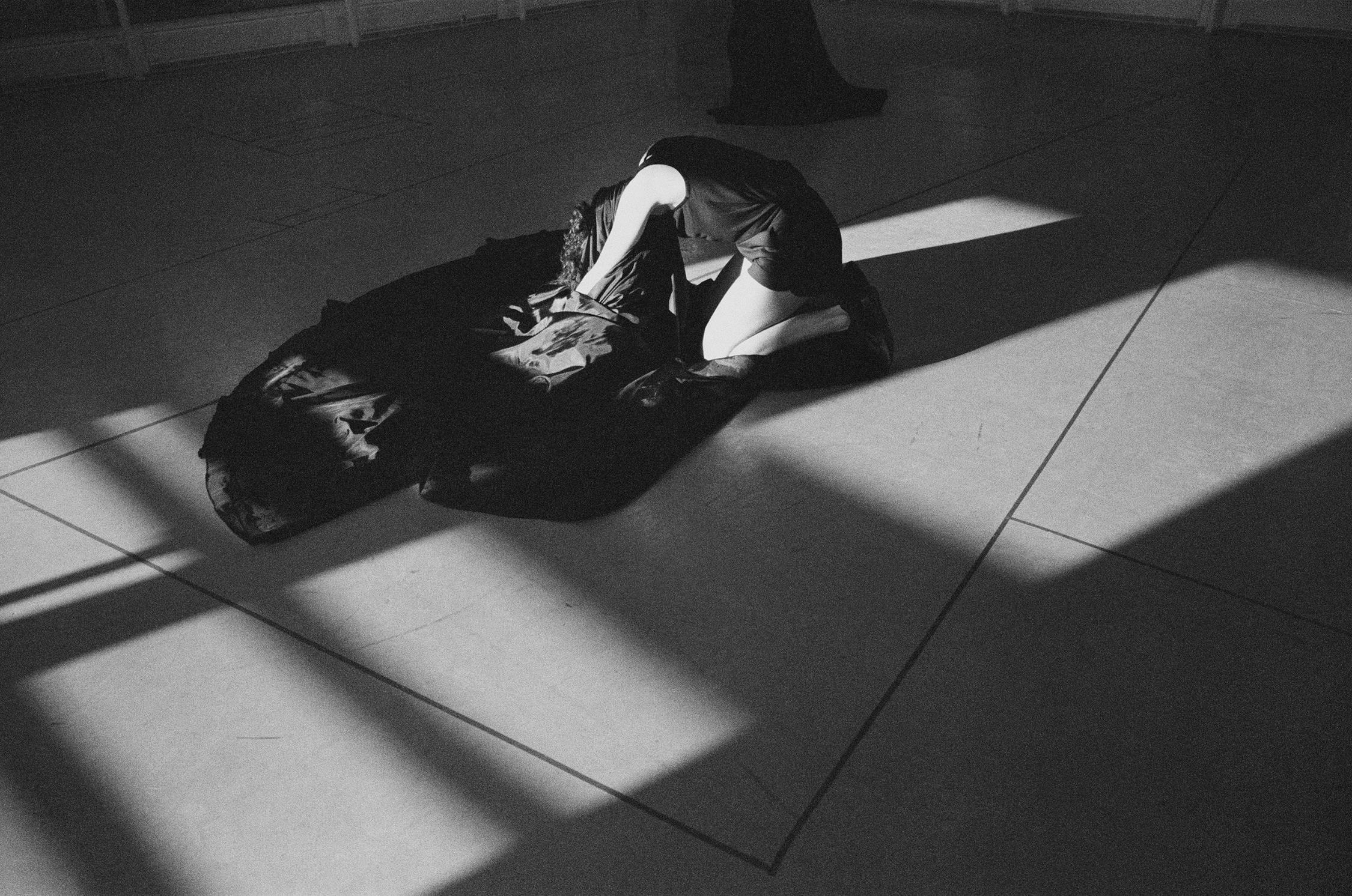 Dancer kneeling on the floor taking off her costume