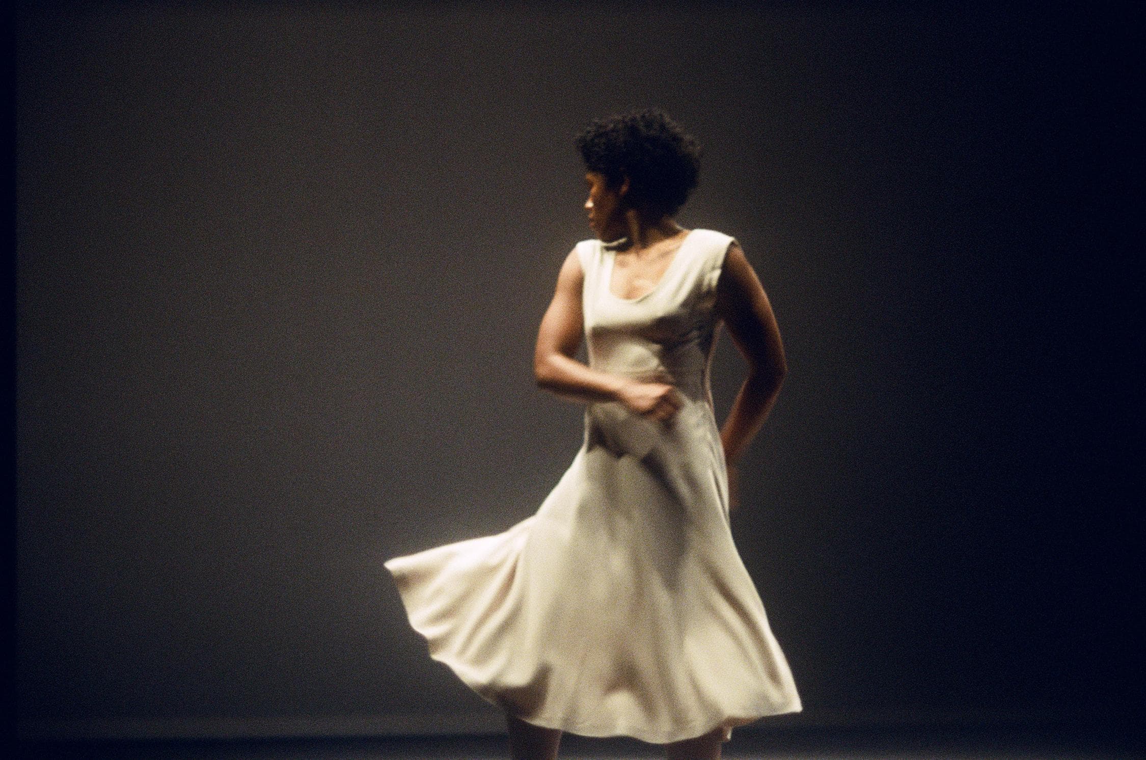 Danseuse en robe blanche regardant vers l’arrière