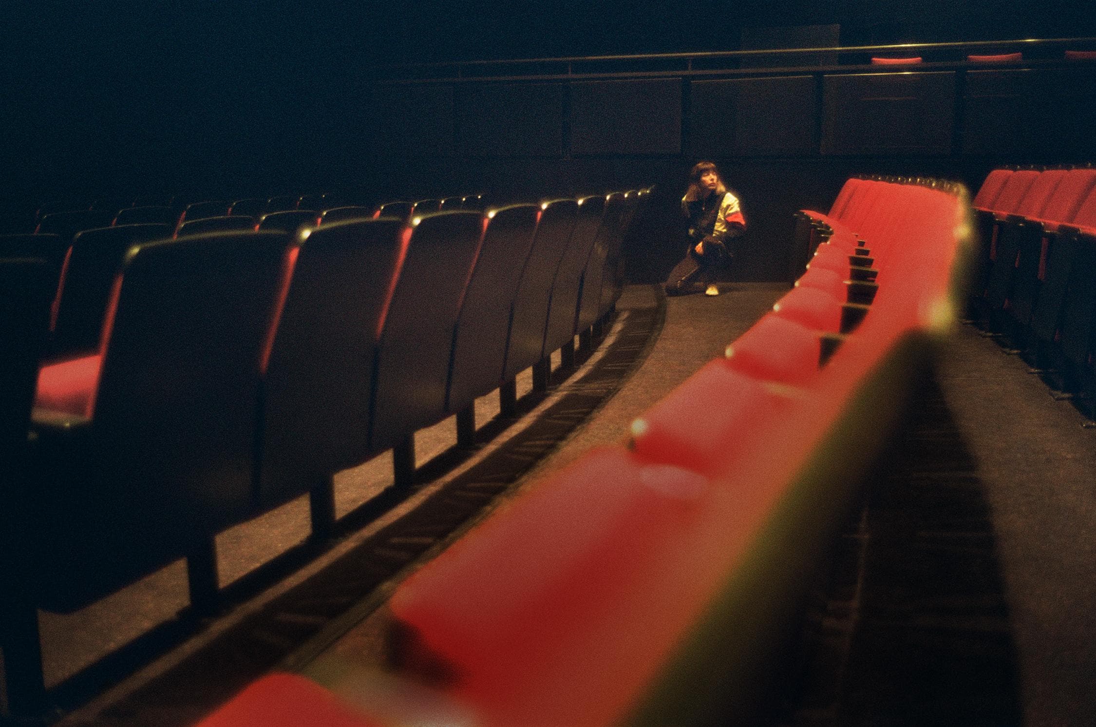 Rows of theater seats with artist in the back