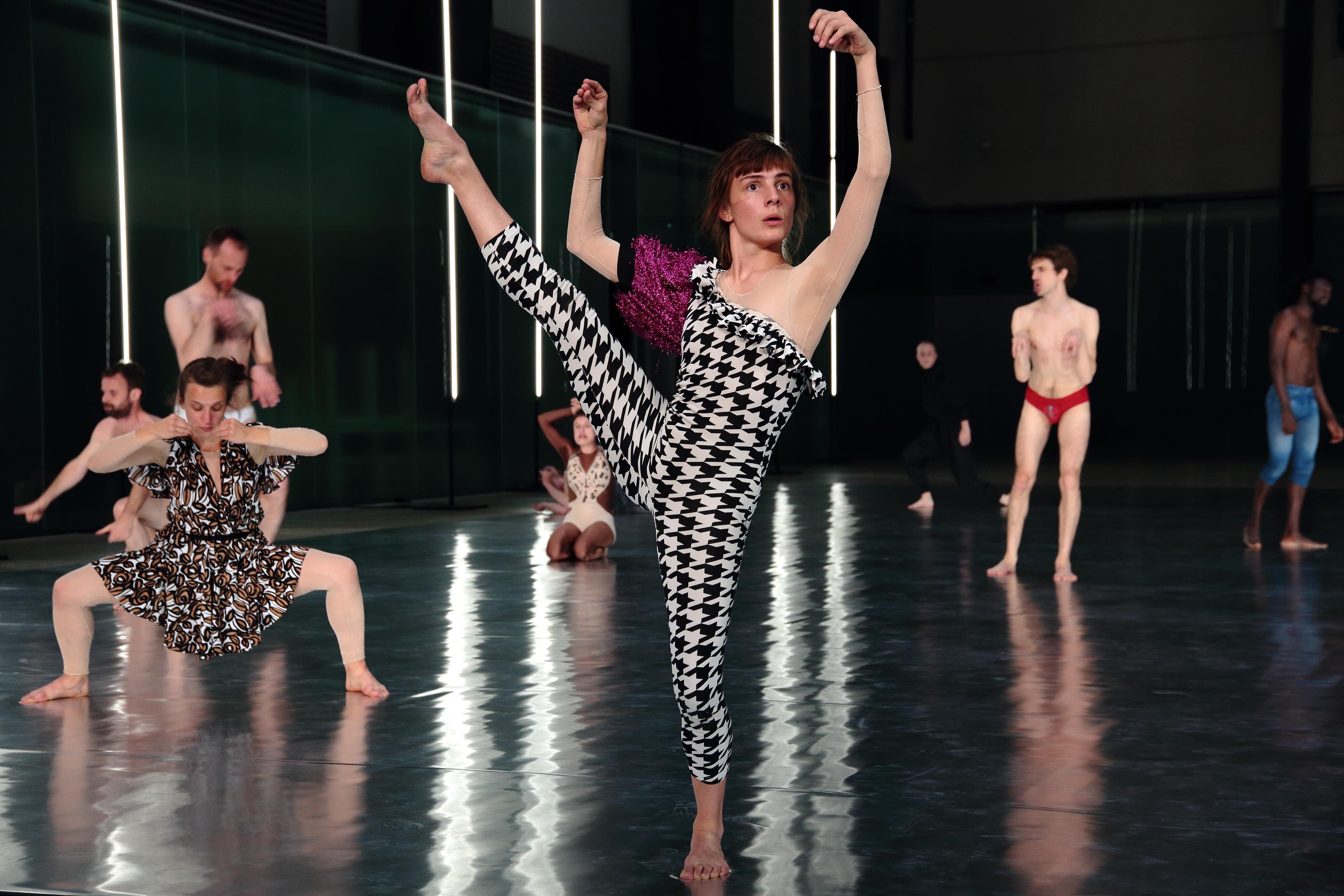 Danseurs de 10000 gestes de Boris Charmatz sur scène, parmi eux une danseuse un pied levé et les bras en l’air