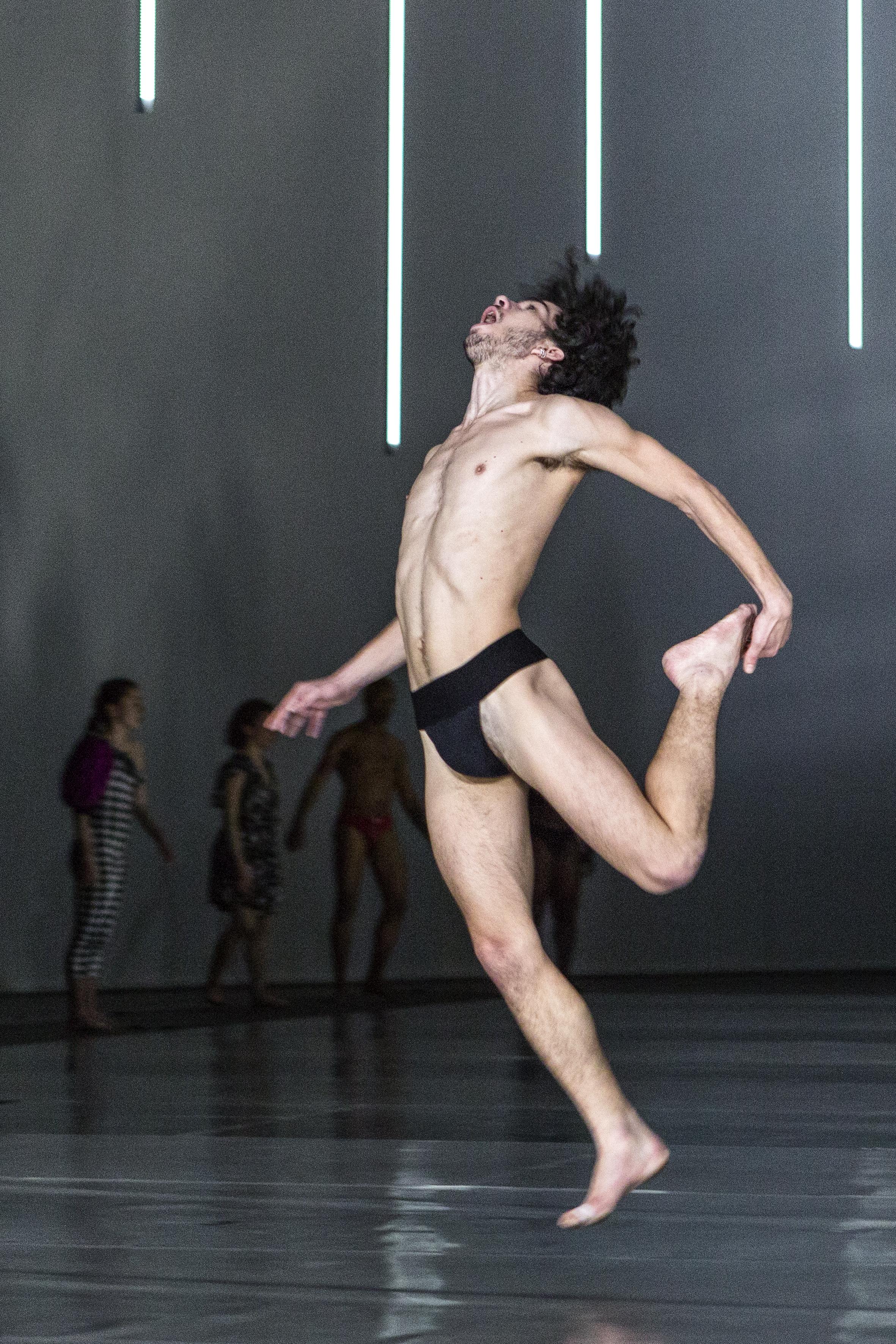 Danseur de 10000 gestes de Boris Charmatz qui saute et tient un pied en arrière
