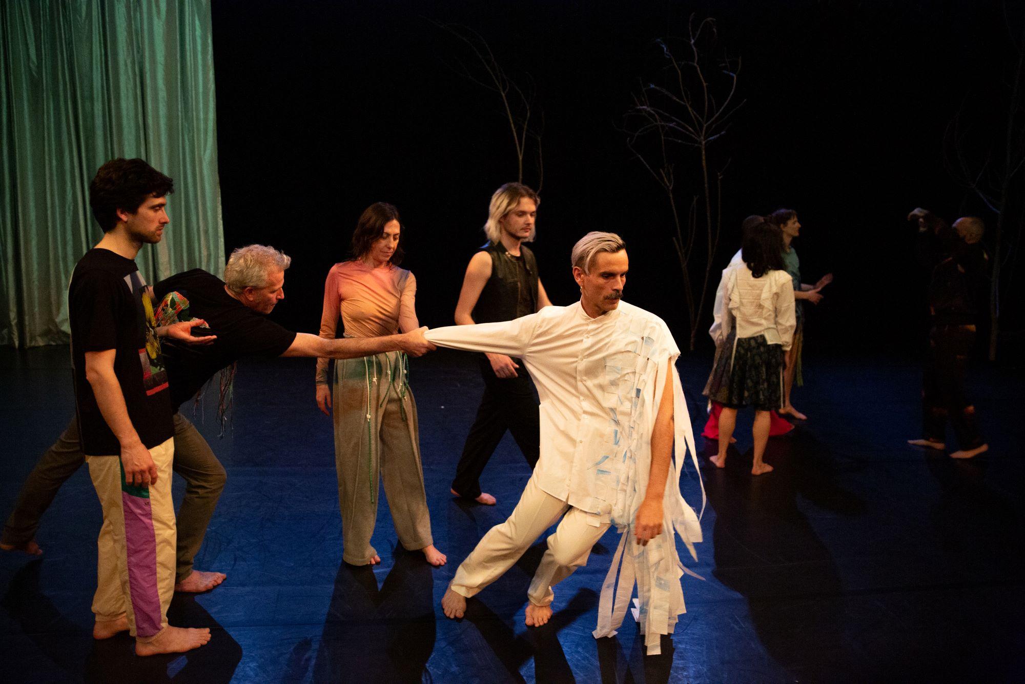 One dancer holding the arm of another dressed in white