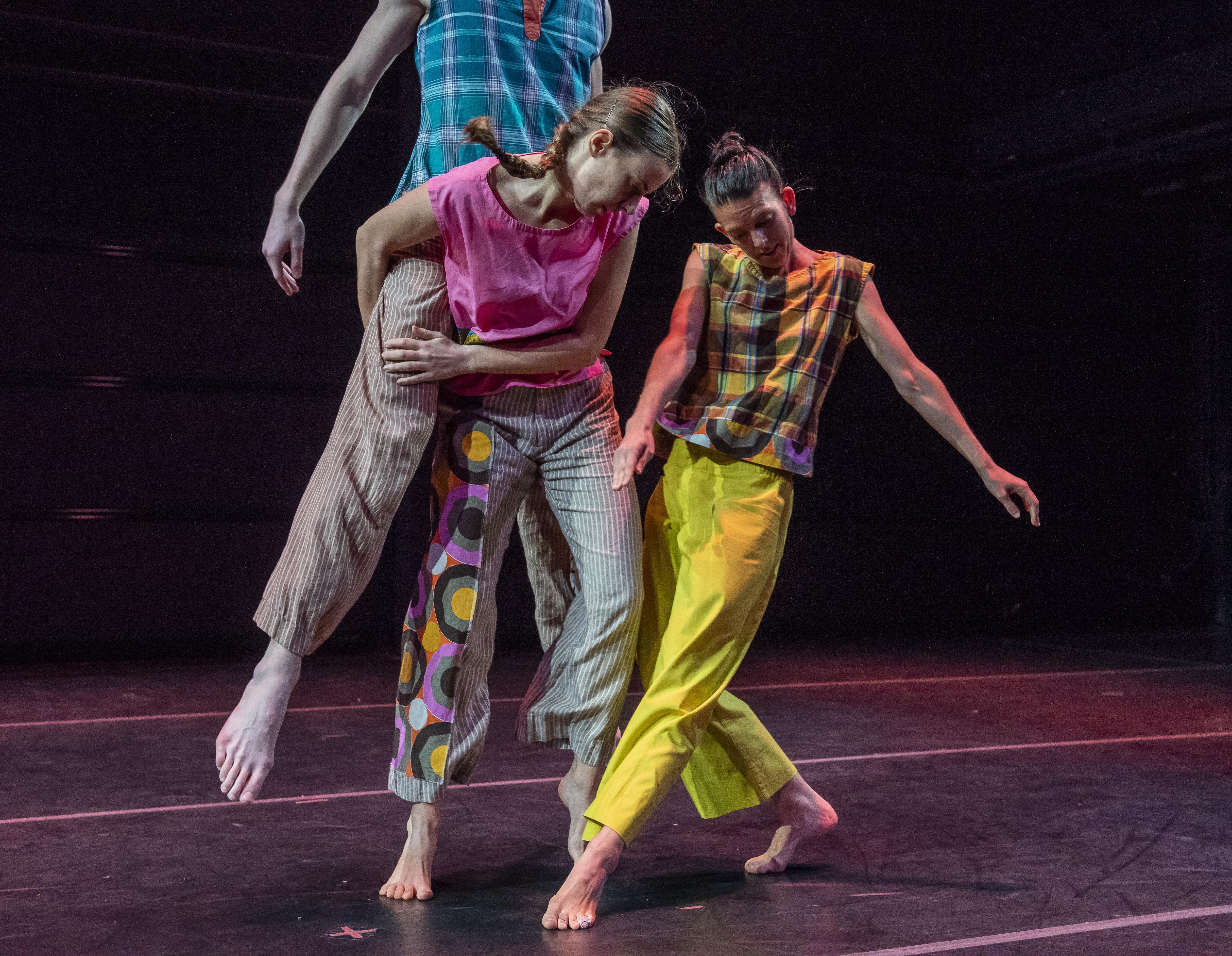 Three dancers dressed colourful
