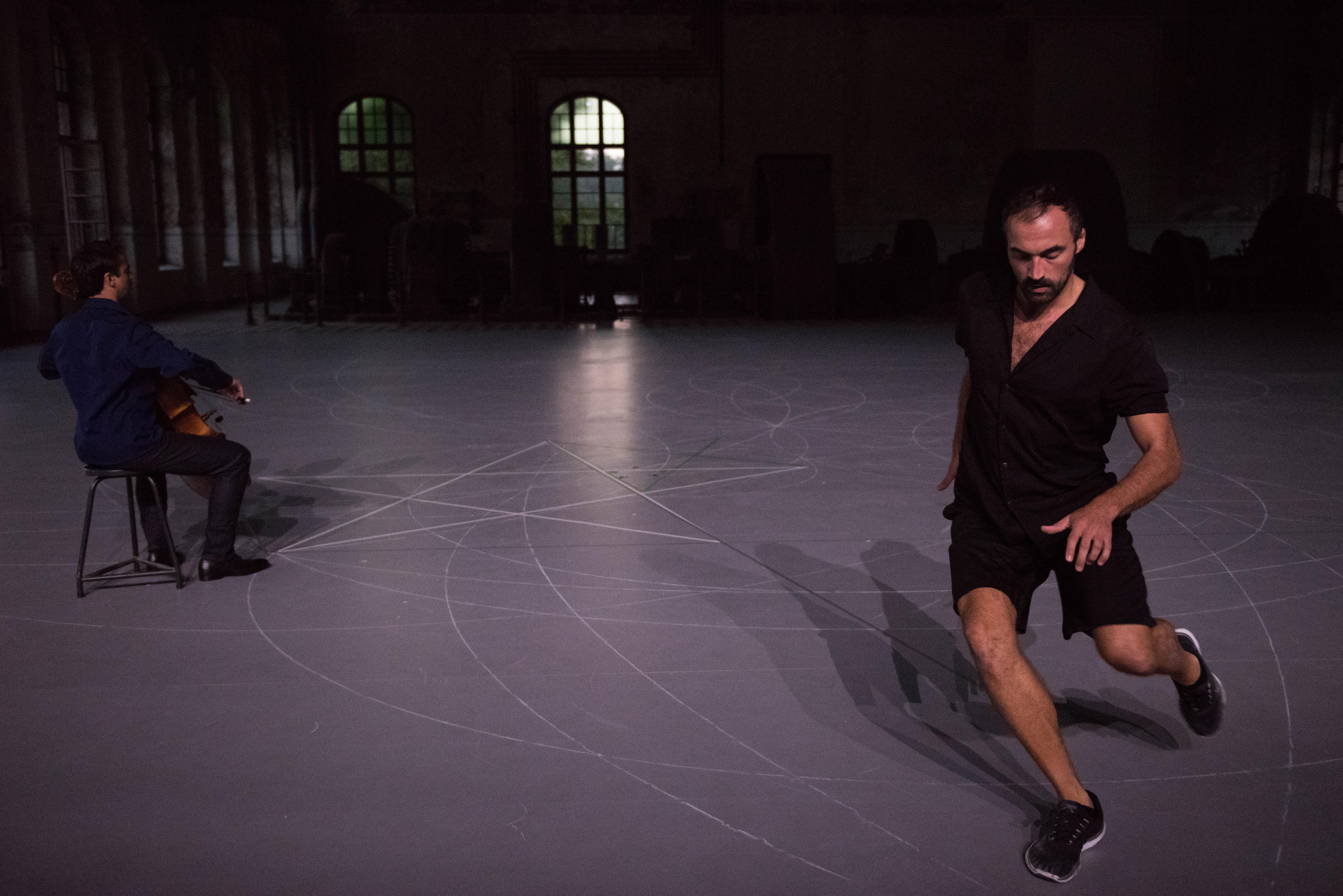 A dancer running around cellist Jean-Guihen Queyras