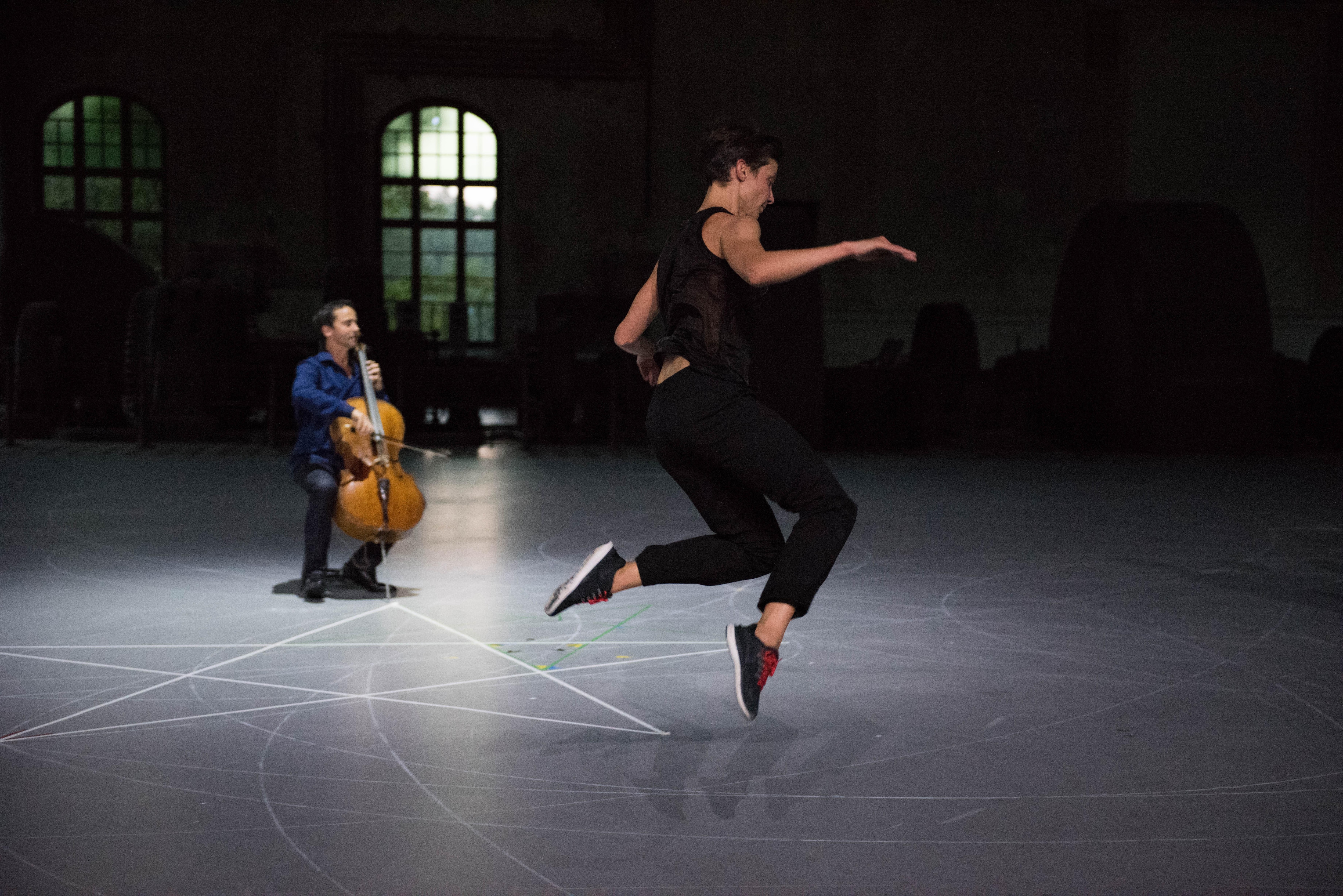 Un danseur en plein saut devant le violoncelliste Jean-Guihen Queyras