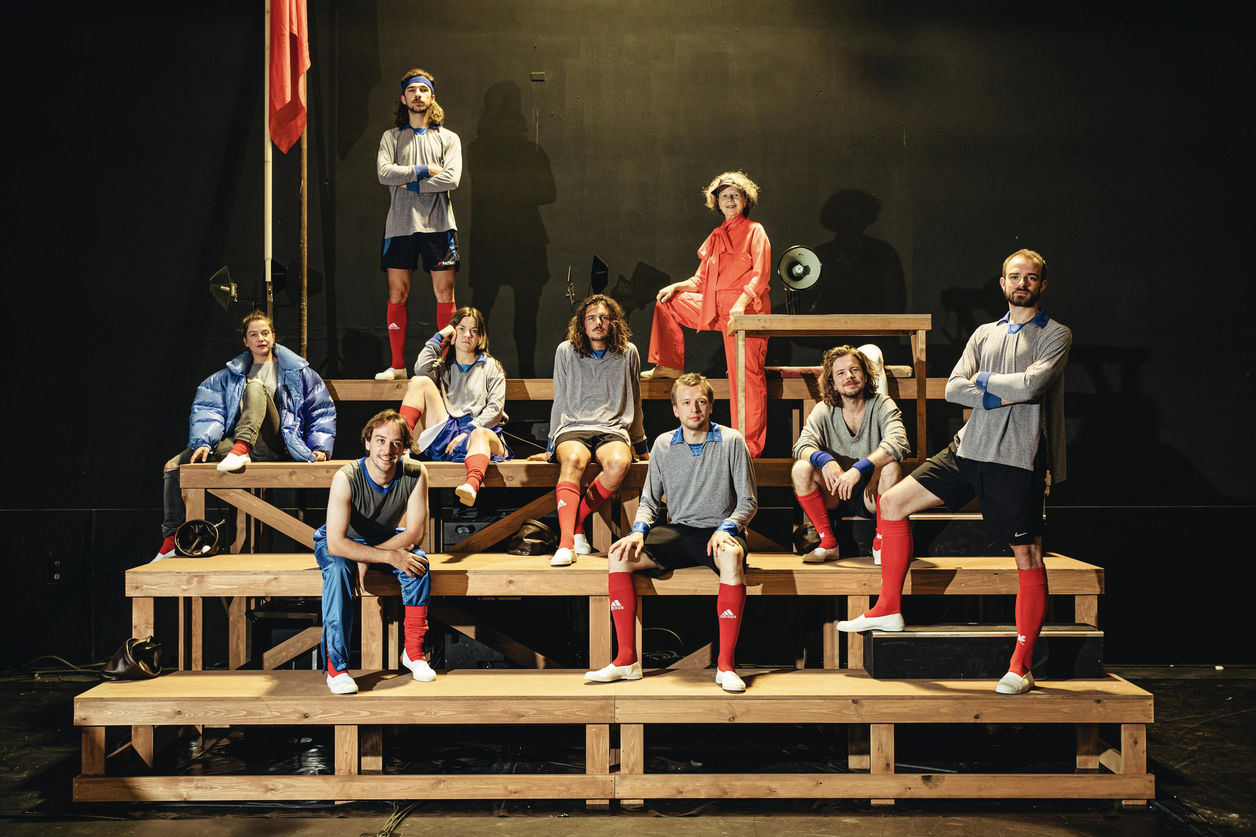 Nine people sitting on the bleachers as if posing for a picture.  