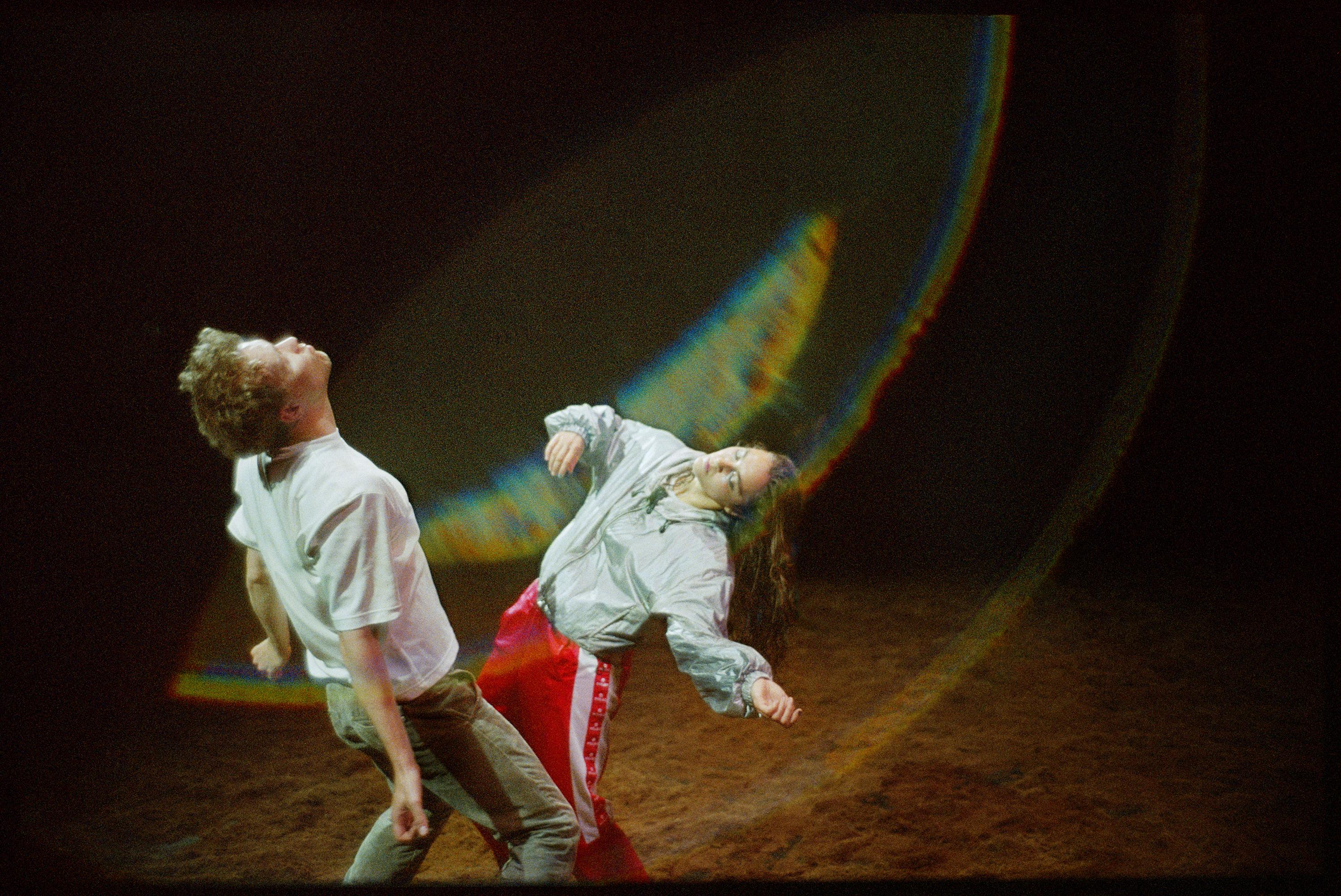 Two dancers twirling on stage, as if taken by the wind.