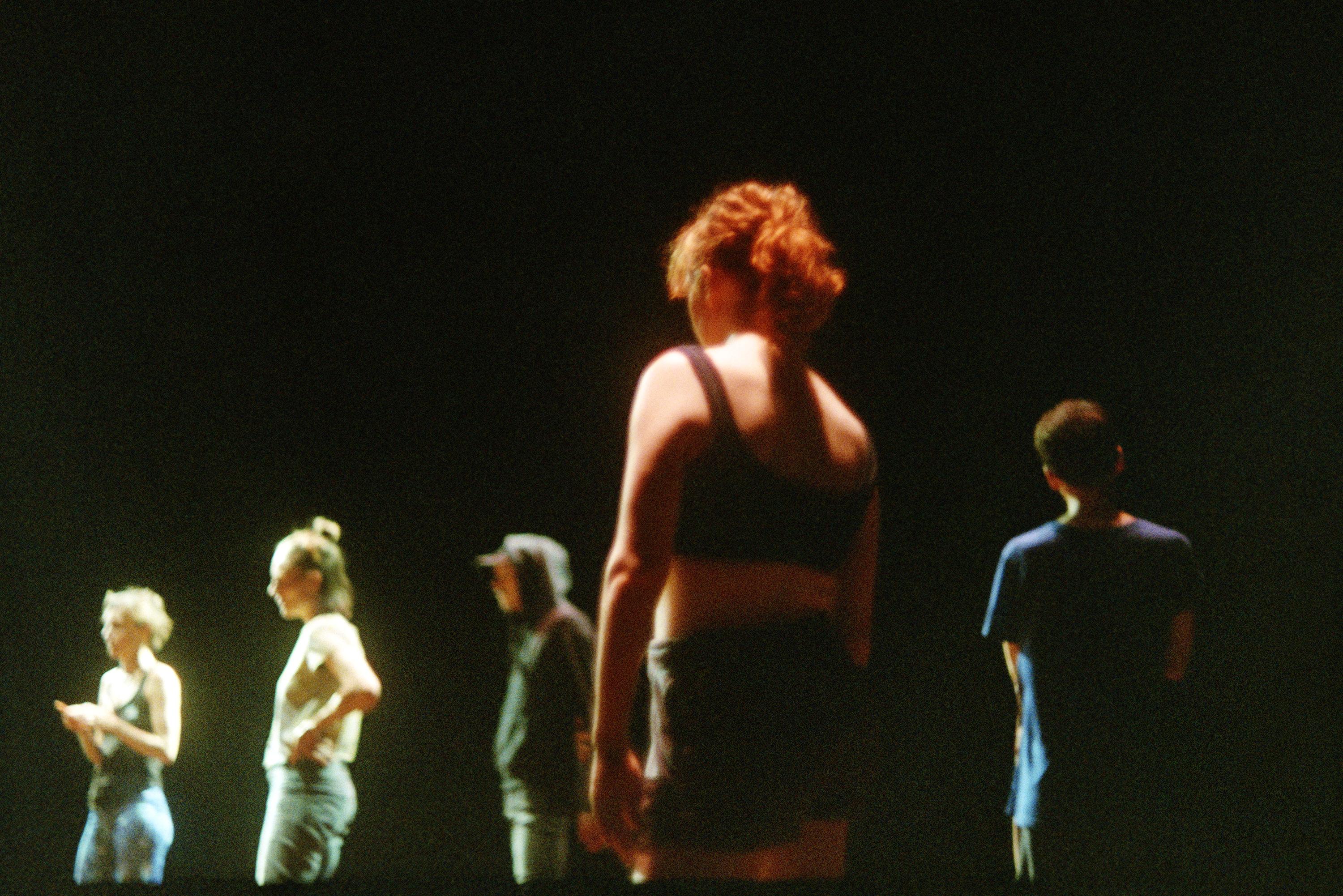 Dancers on stage, standing during a rehearsal