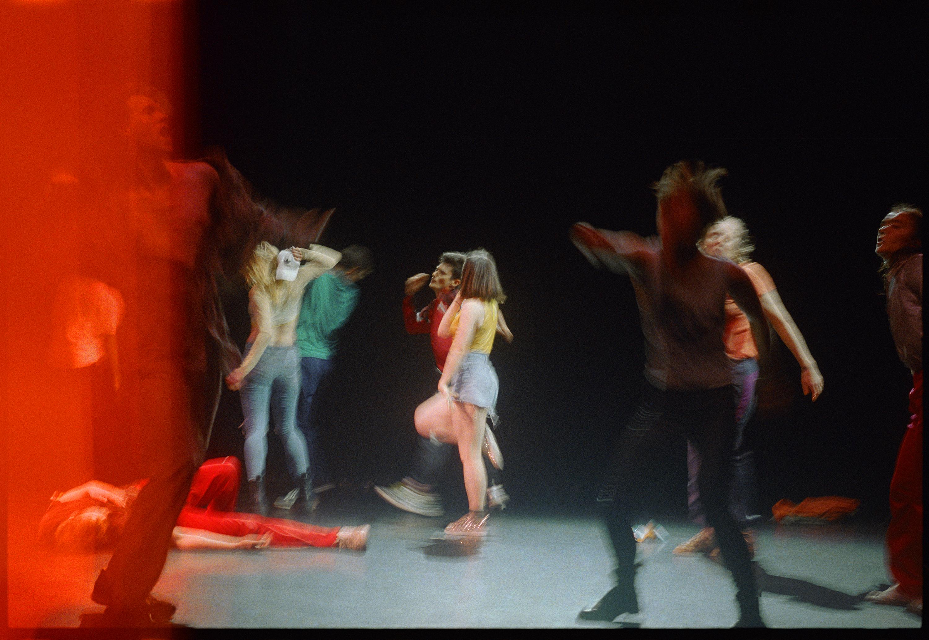 Dancers in movement during a rehearsal on stage