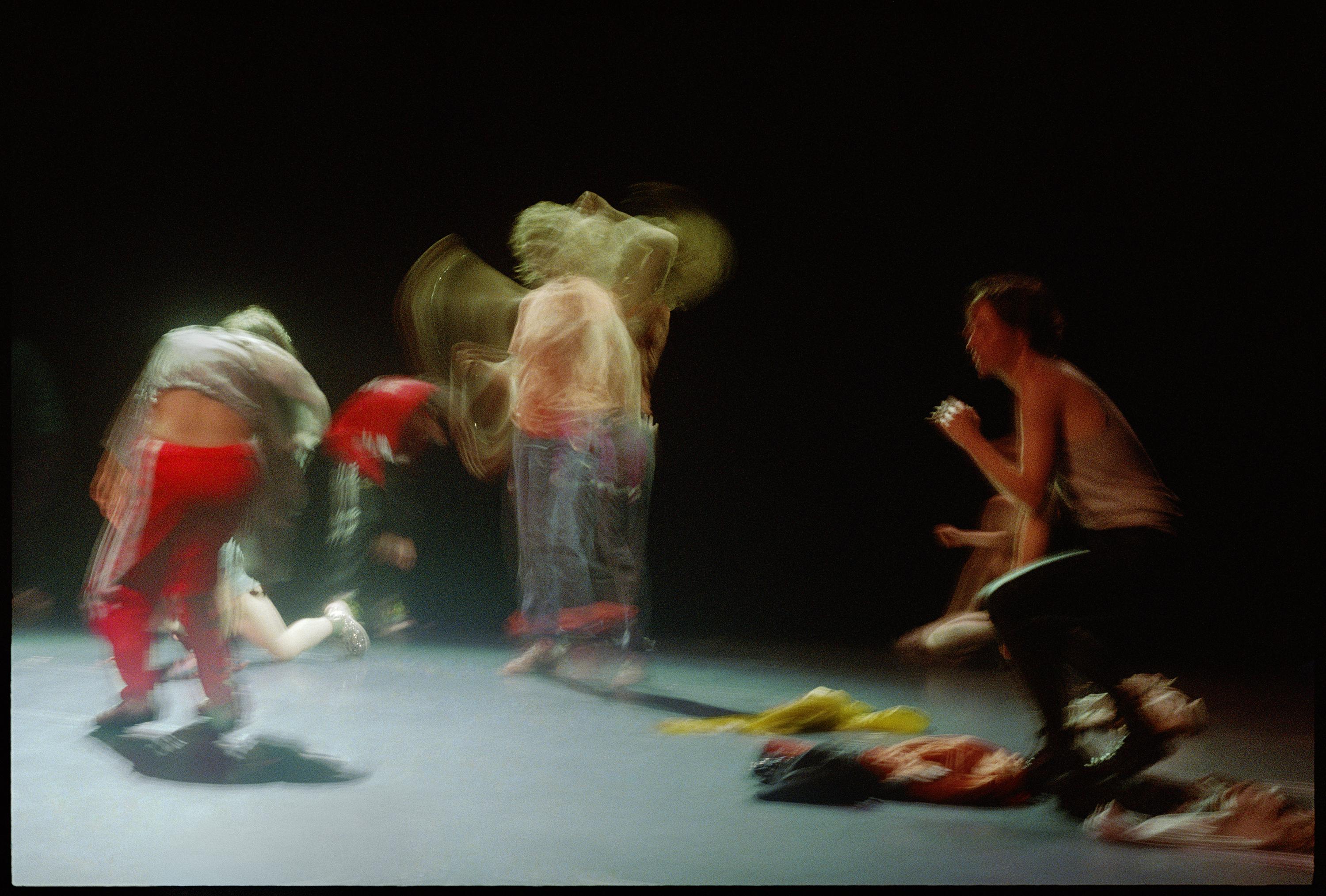 Dancers in movement during a rehearsal on stage