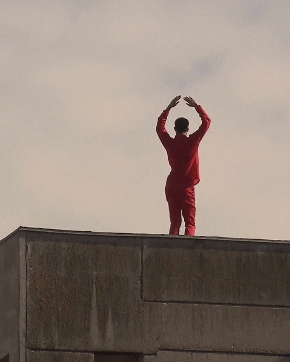 Person in red dancing on a roof