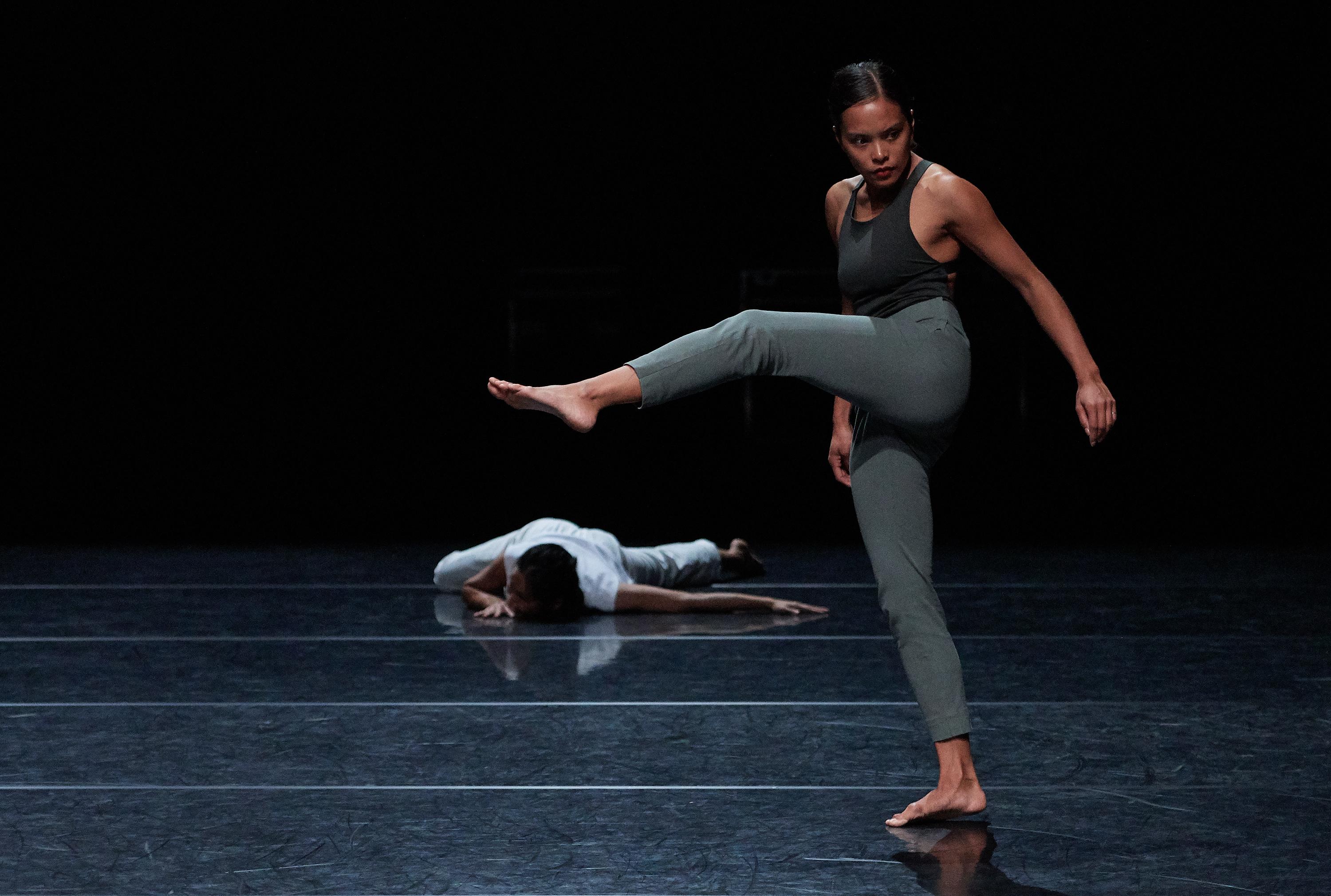 Dancer front stage, one leg up. Another dancer is behind her, on the ground.