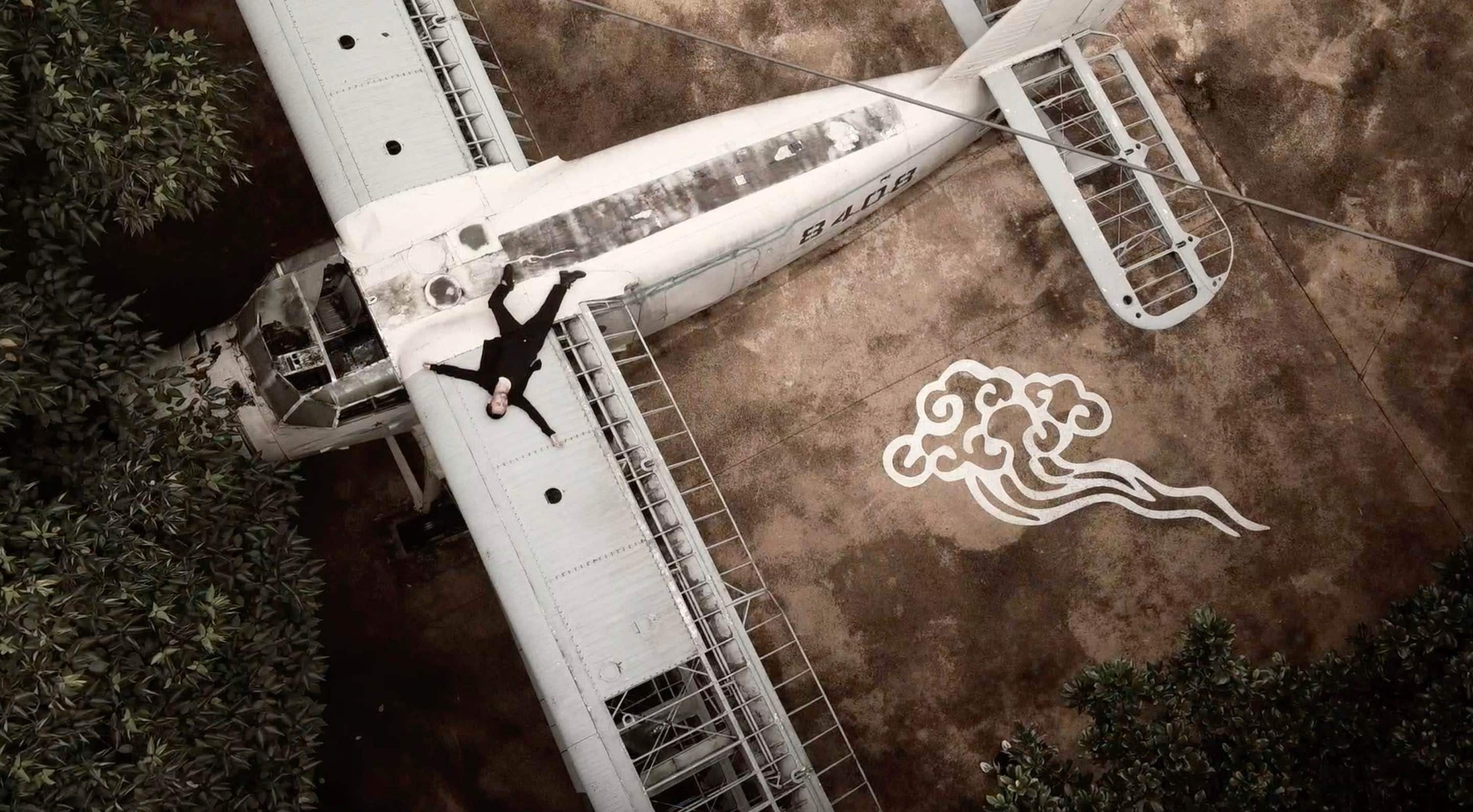 Man lying on the back of a small plane