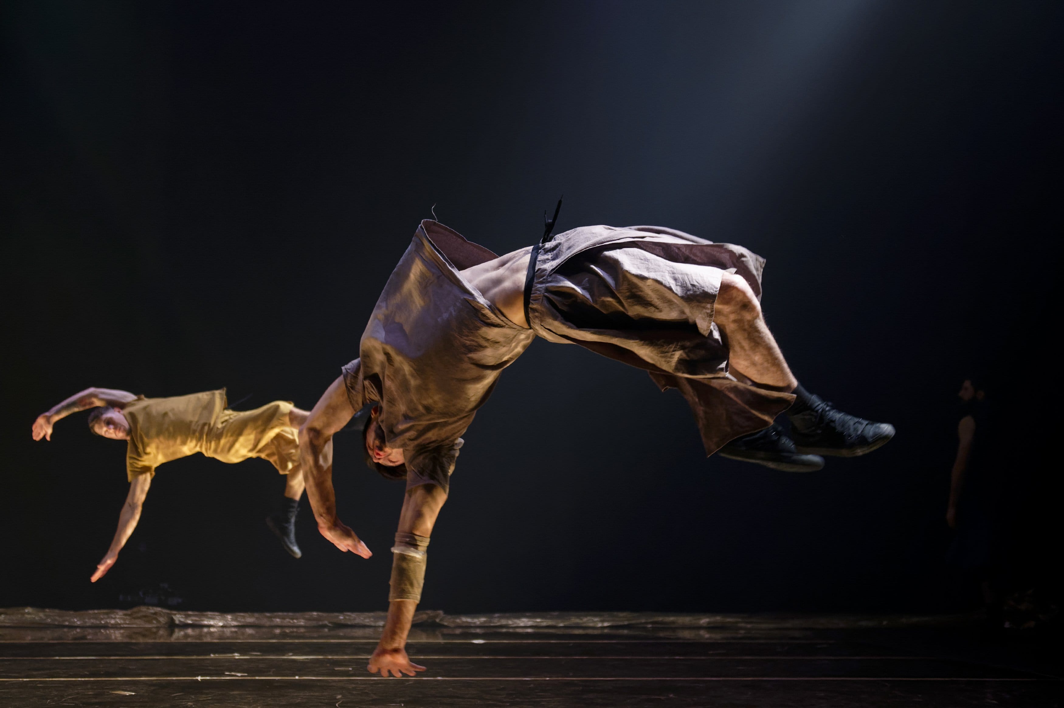 Two dancers jumping backwards