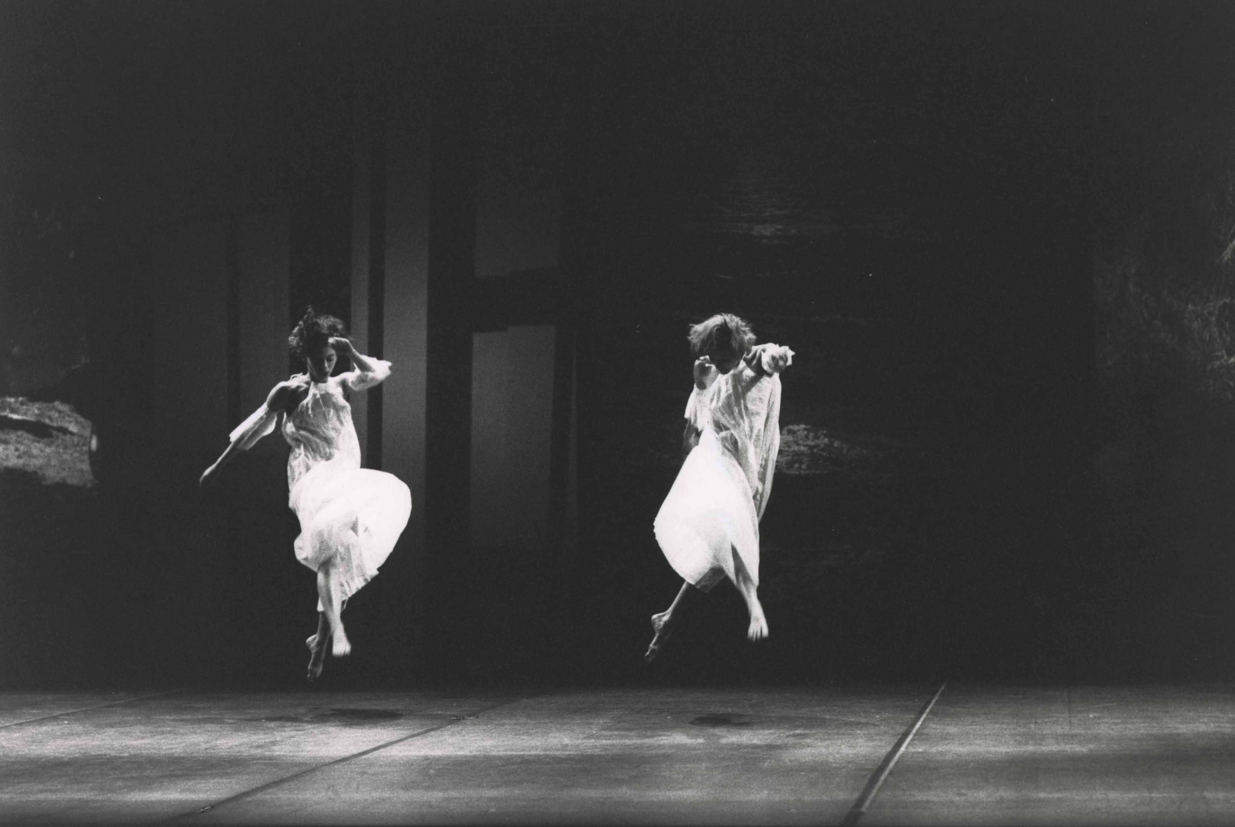 Two dancers jumping in Glacial Decoy by Trisha Brown