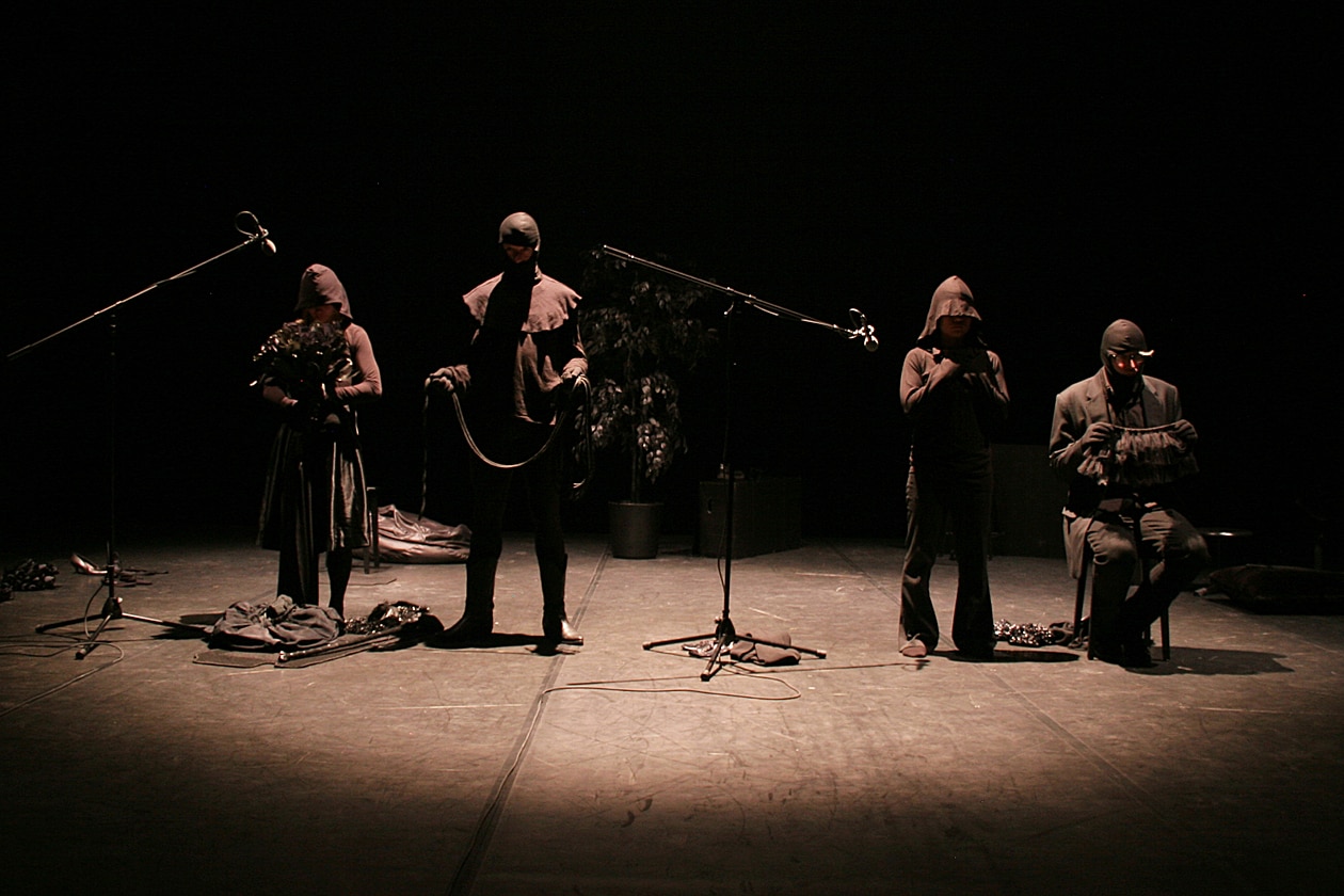 Group of four musicians on stage in the half-light 