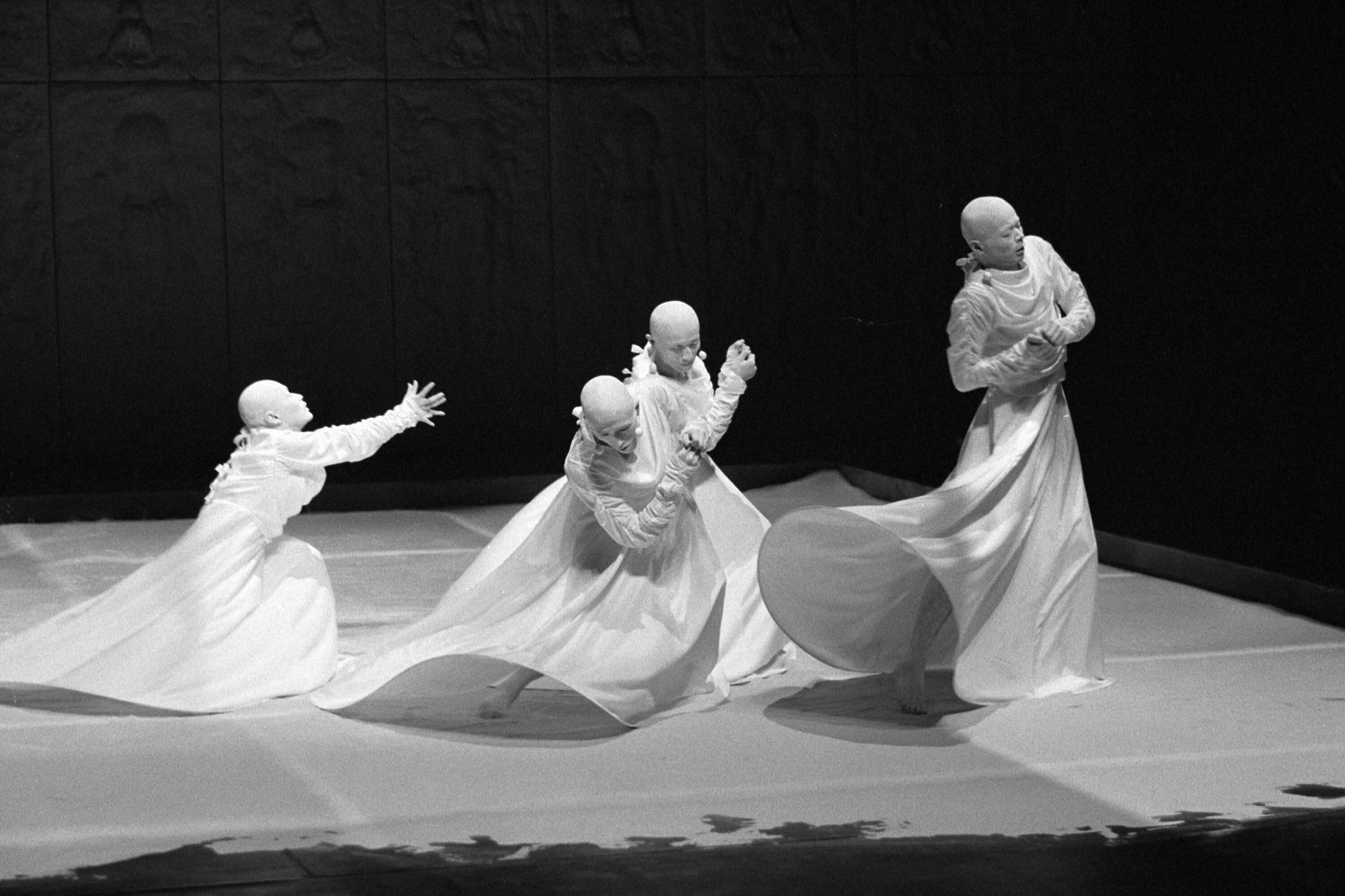 4 dancers in white gowns on stage