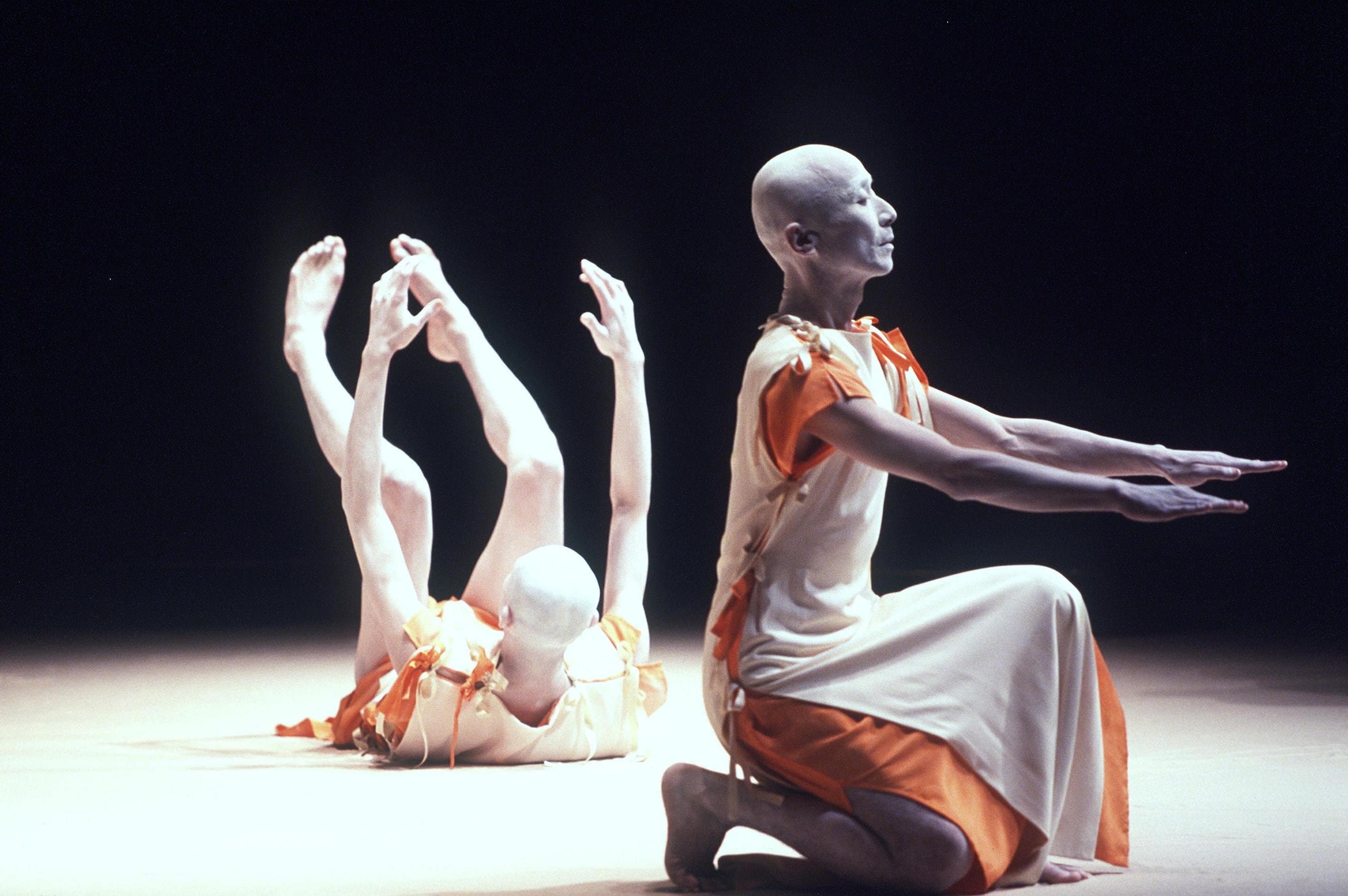 Two buto dancers in full performance on stage